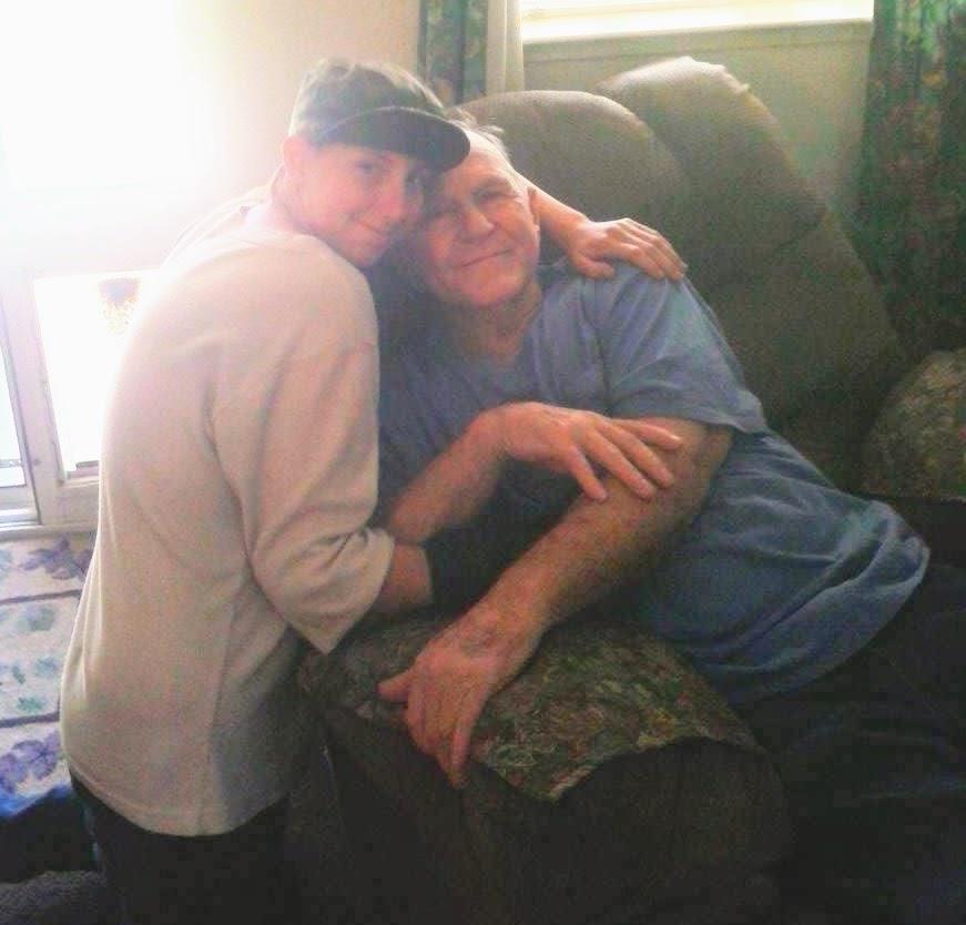 A young person and an elderly individual are joyfully embracing while seated on a comfortable couch.