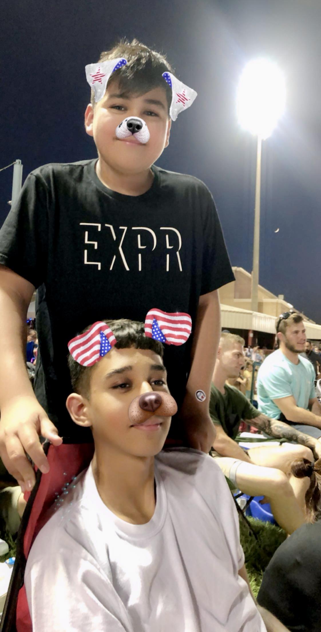 A boy standing next to a boy with a nose and ears on his head