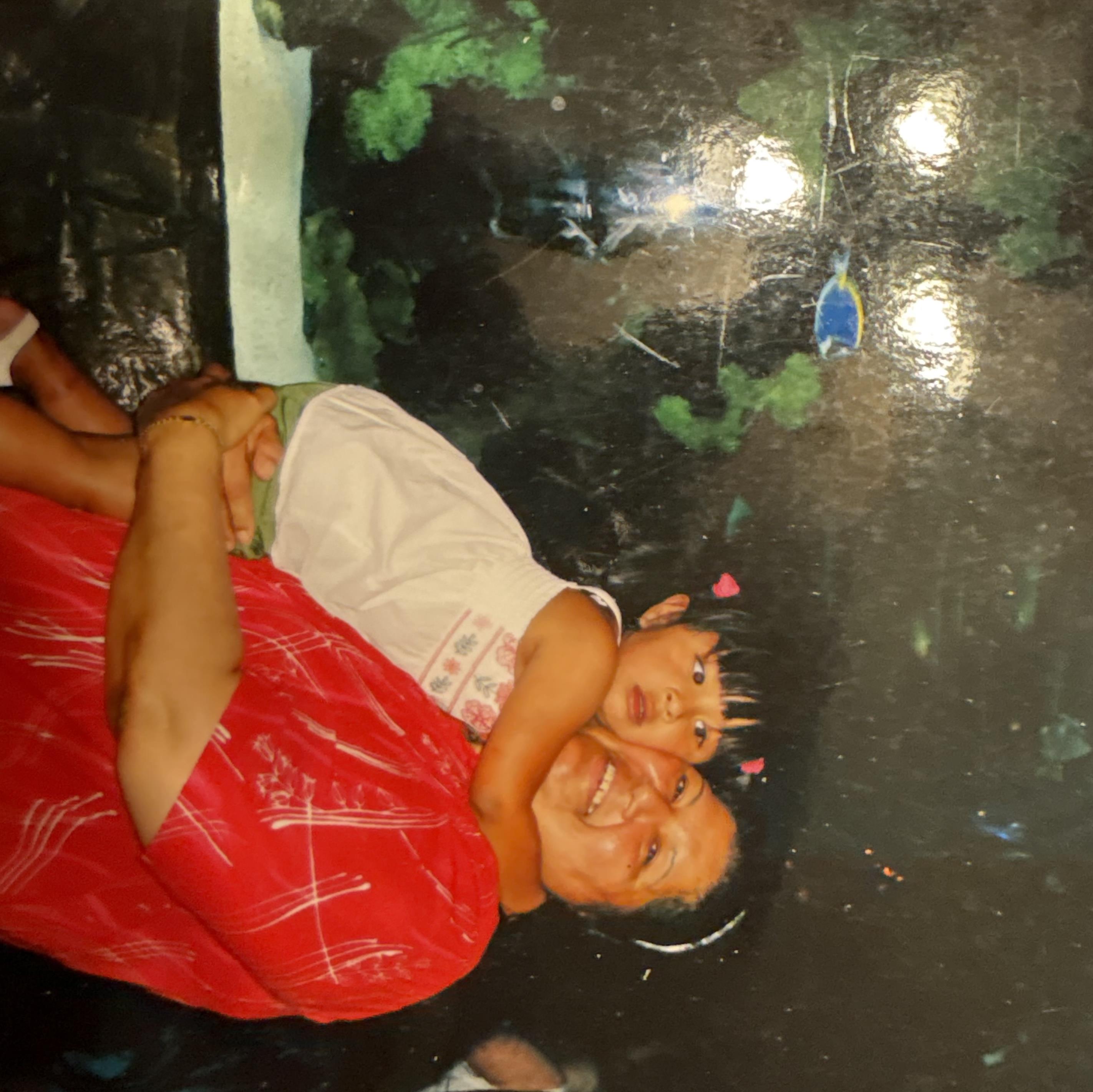 A cheerful man joyfully carries a happy child in a colorful, vibrant space.