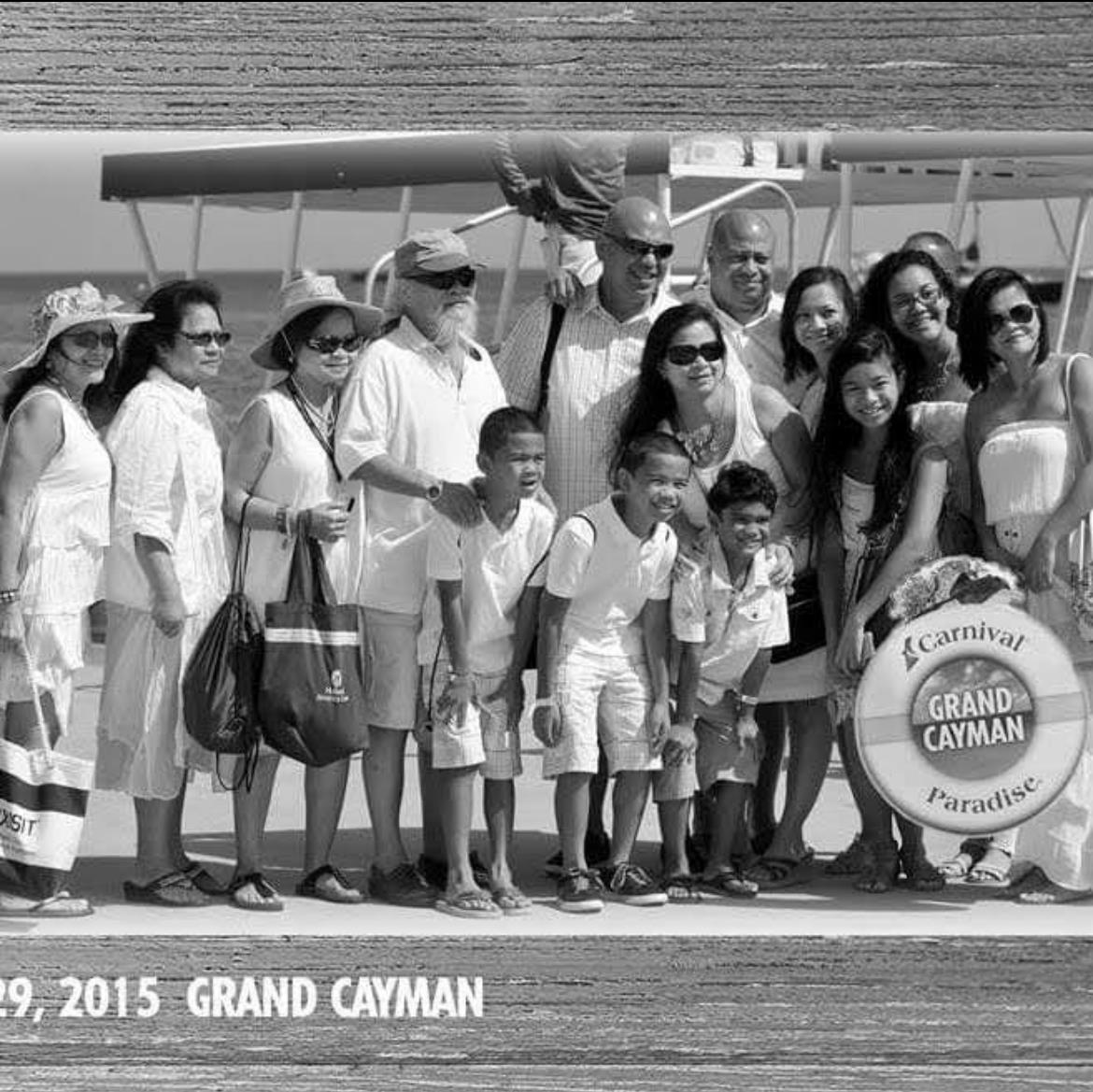 A joyful group of family and friends poses together near a seaplane in Grand Cayman.