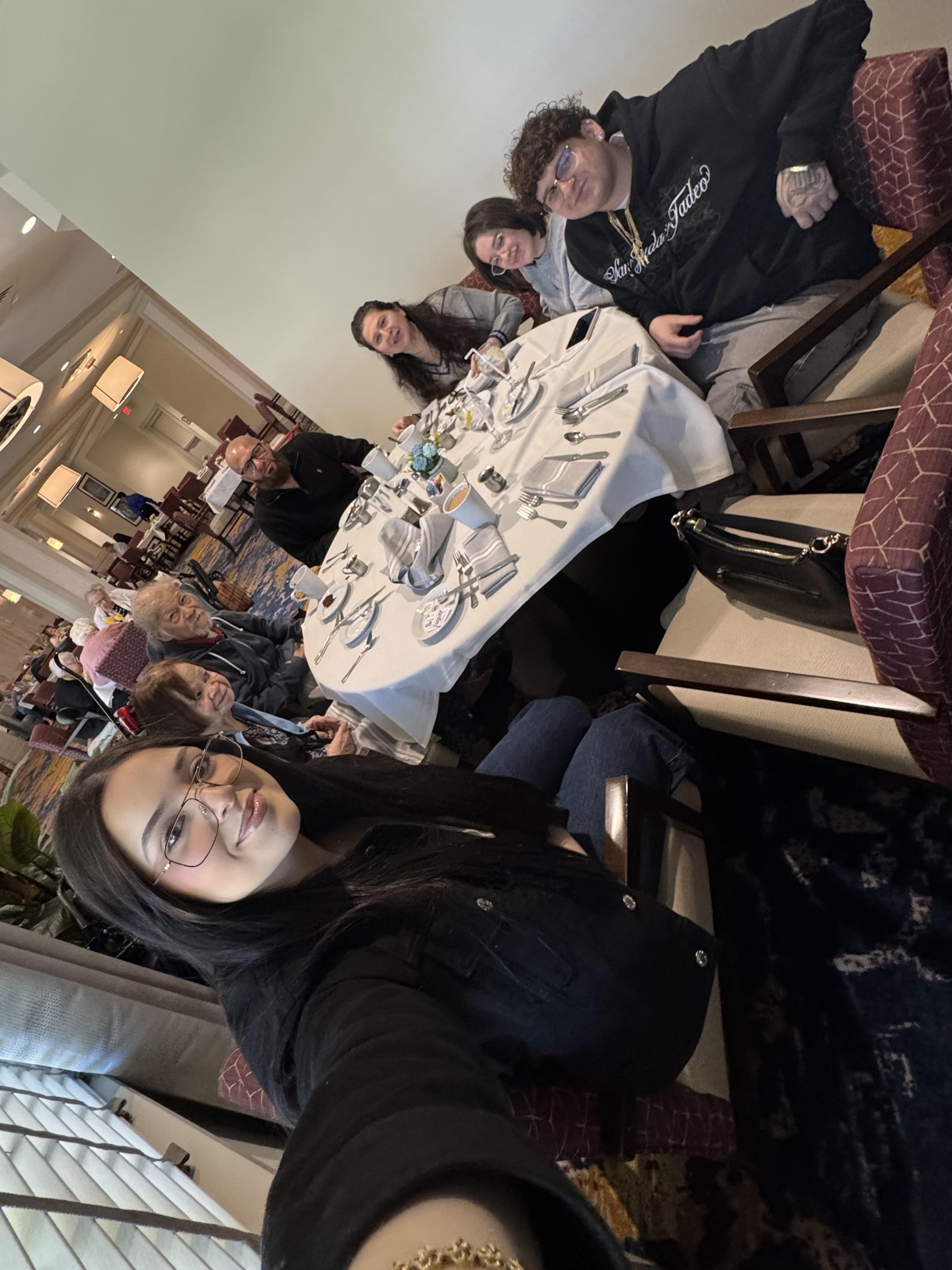 Friends gather around a table at a restaurant sharing laughter and conversation during dinner.
