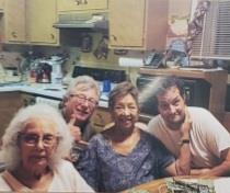 Four family members enjoy quality time together around a kitchen table, filled with joy and smiles.