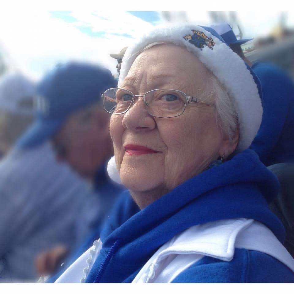 Crowds cheer and celebrate at a winter festival, showcasing vibrant blue outfits and warm smiles.