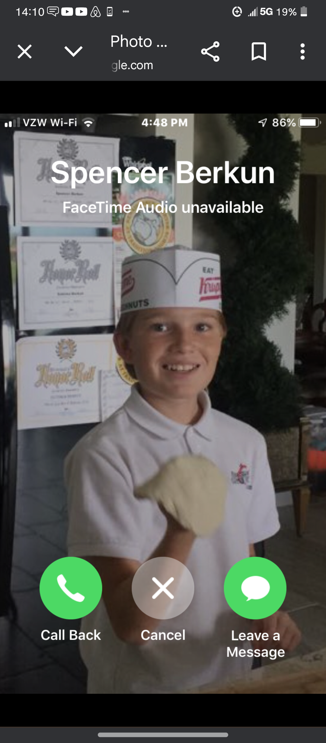 Child wearing a chef hat joyfully shapes pizza dough while smiling in a lively eatery.