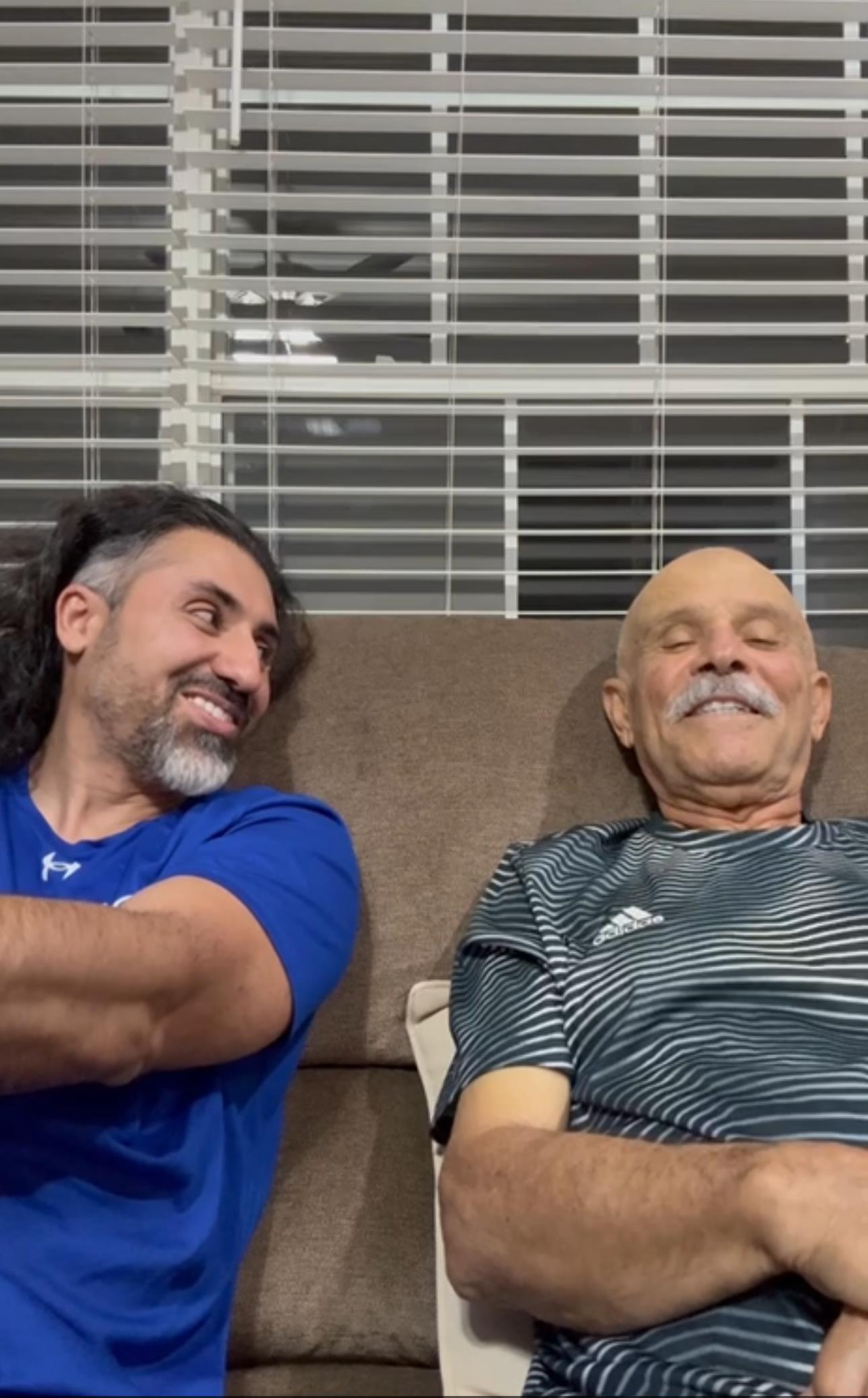 Two smiling men enjoy a lighthearted moment while seated in a warm, inviting living room.