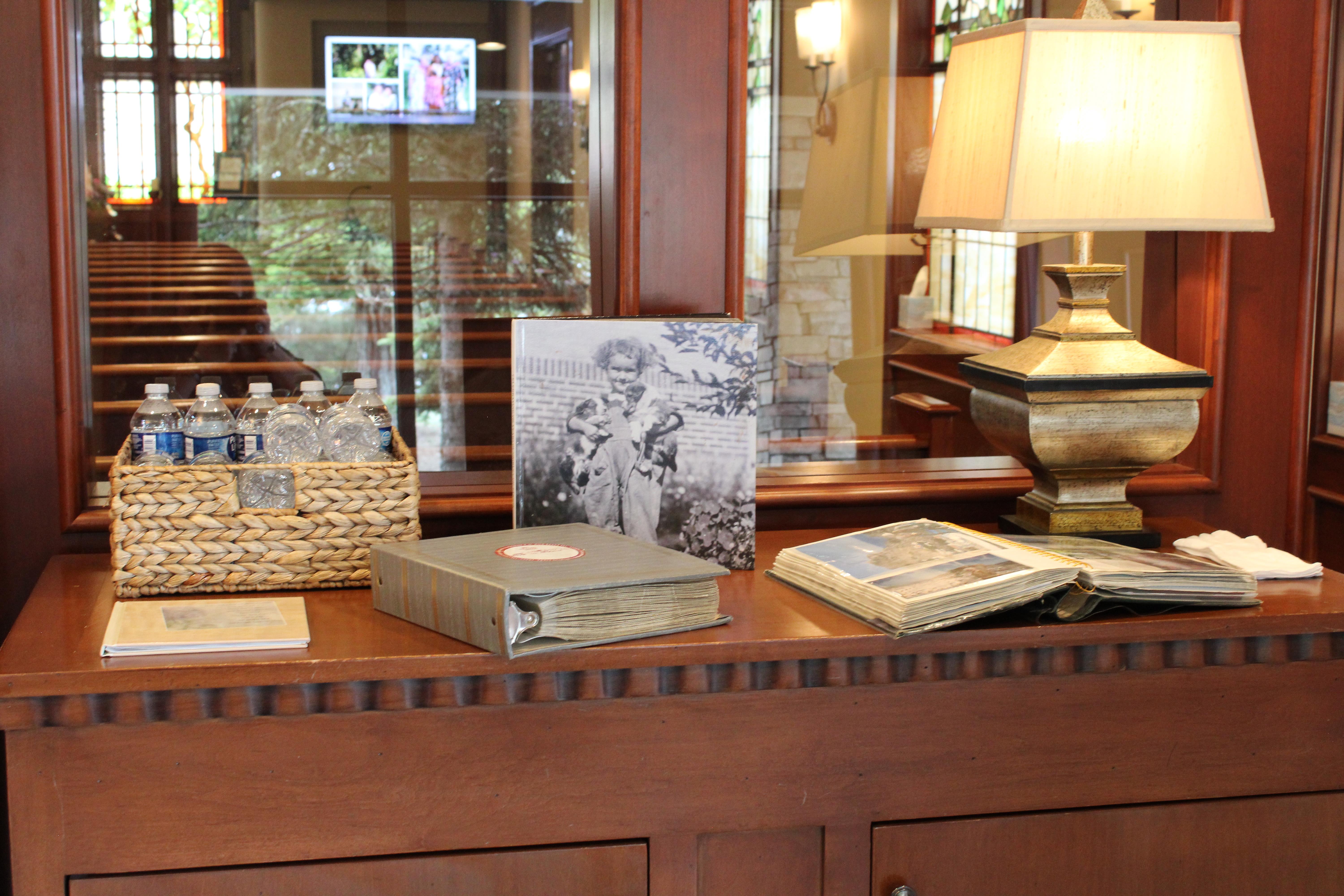 A wooden counter showcases vintage books, a framed picture, and a basket filled with water bottles.
