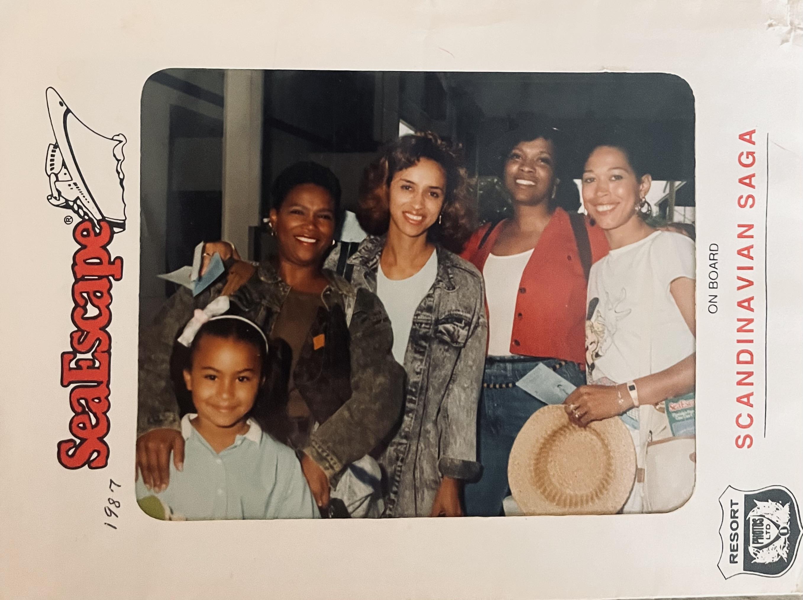 Five friends pose together, smiling and enjoying a memorable moment at a lively event outdoors.