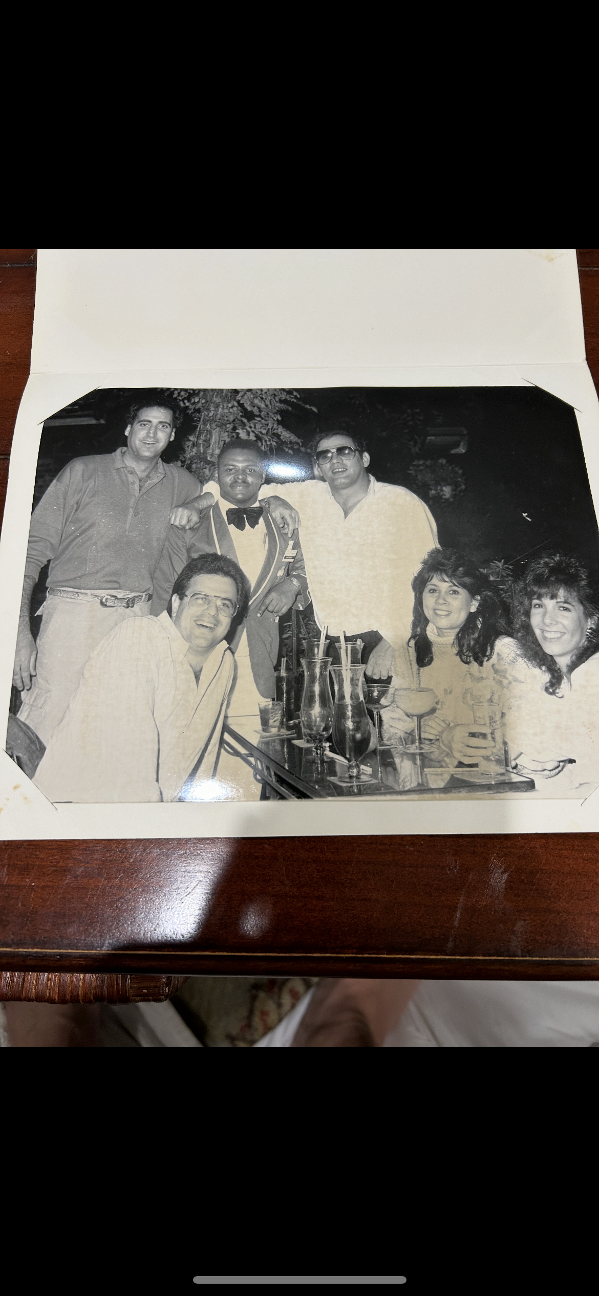 Friends gather around a table with glasses, sharing laughs and enjoying an evening together.