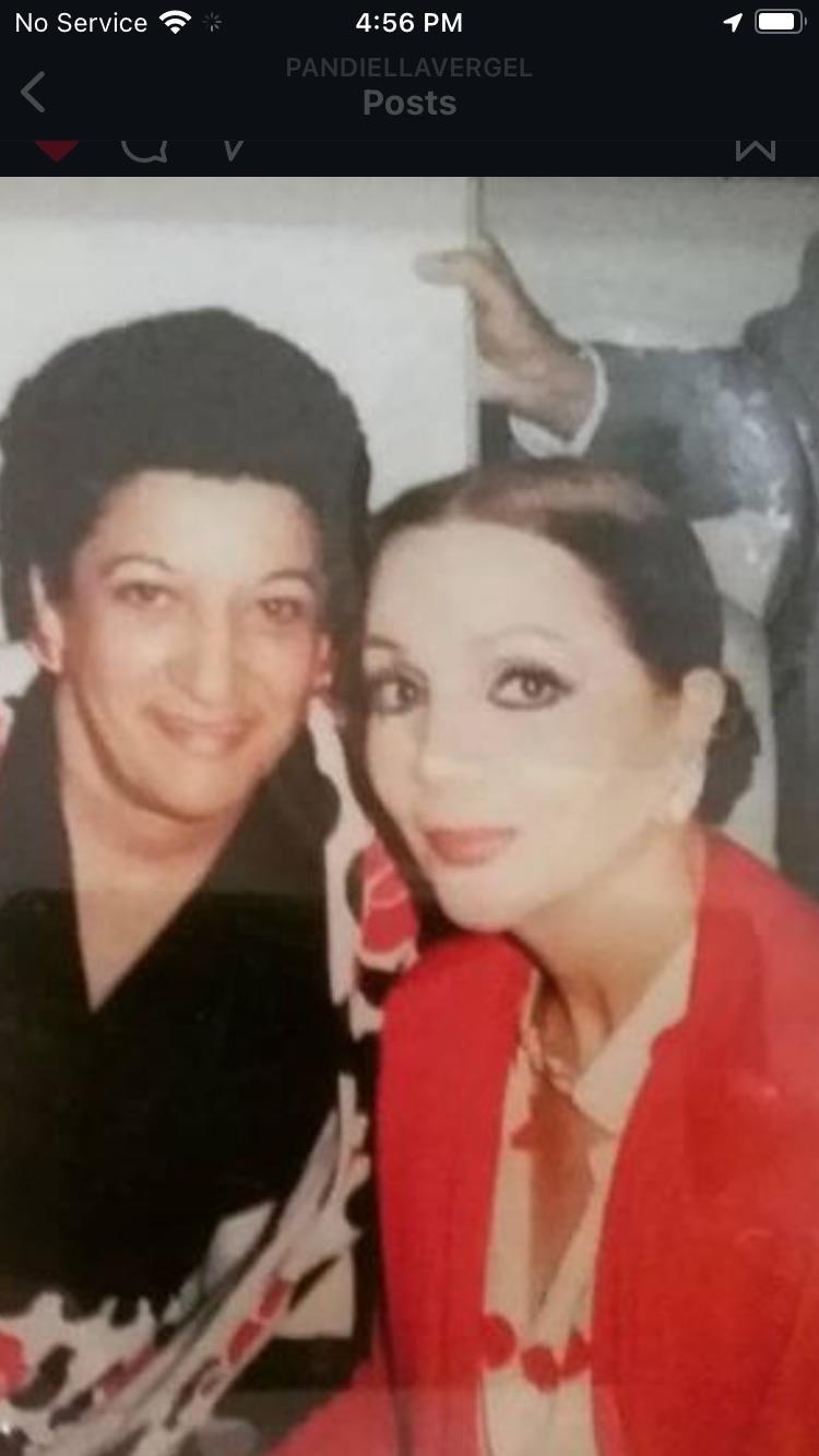 Two women smile at each other, showcasing friendship during a social gathering with lively energy.