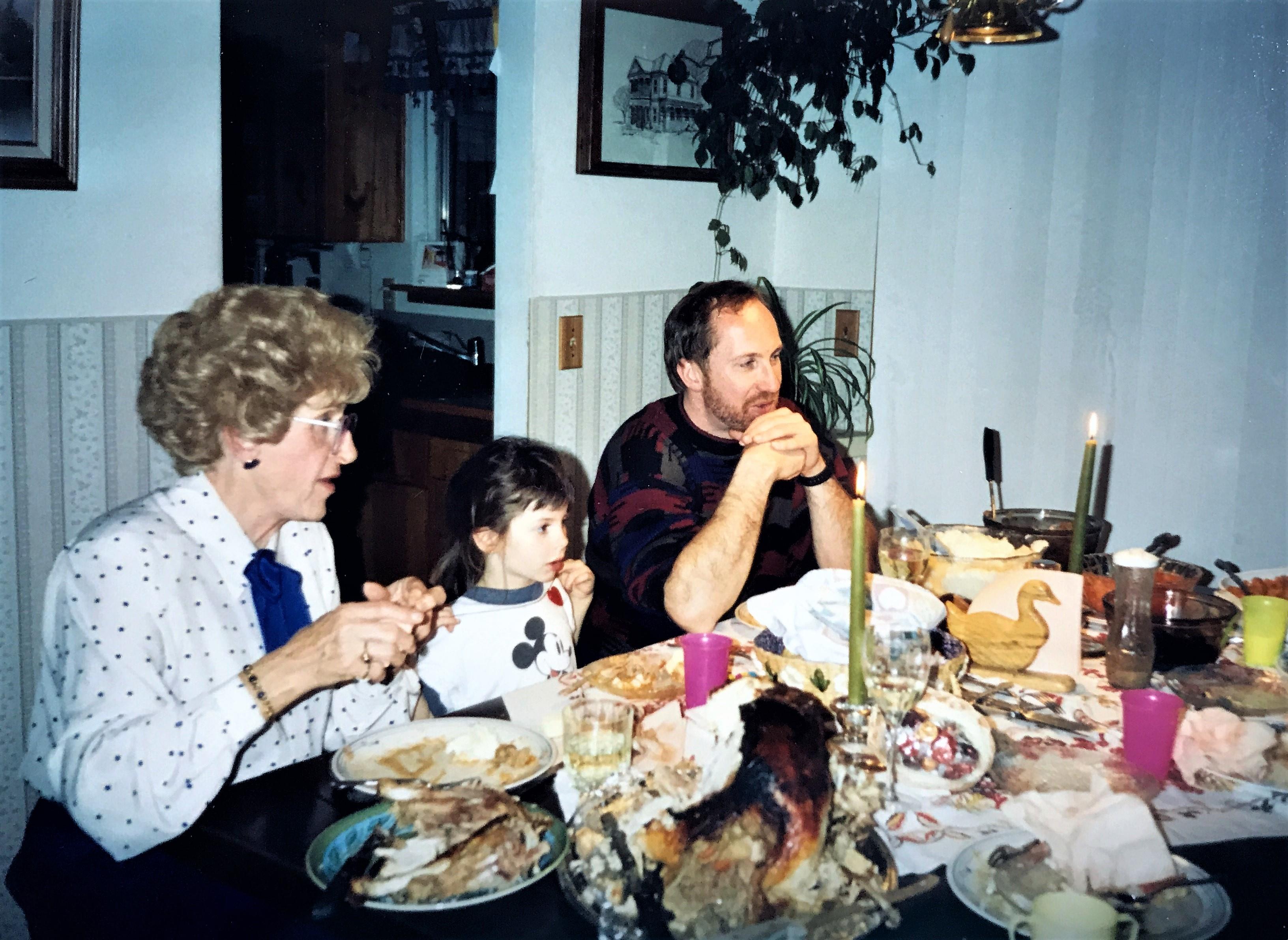 Relatives engage in lively conversation during a cozy family meal filled with dishes.