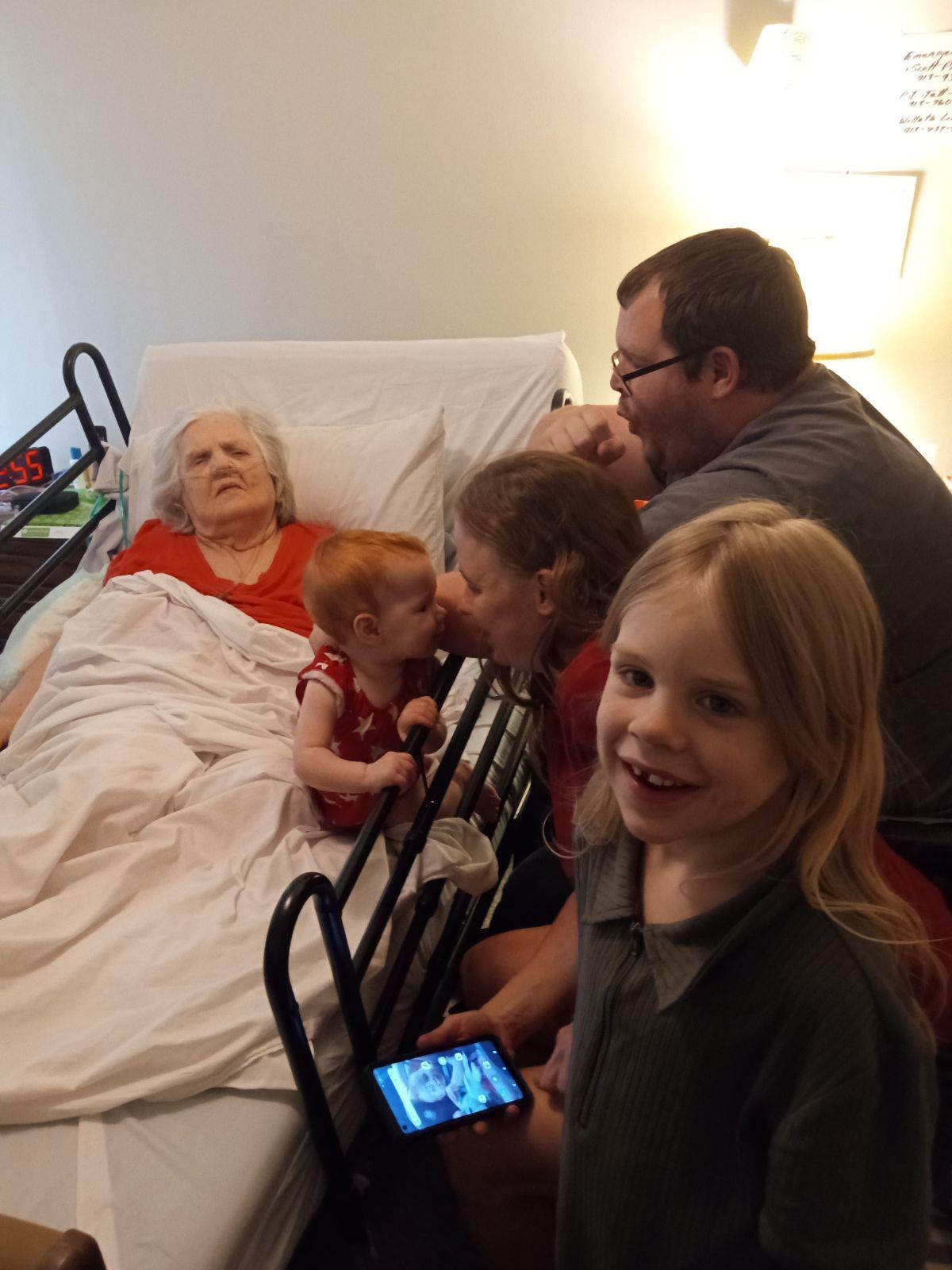 Family cherishes time together, sharing laughter and warmth with their elder in the hospital.