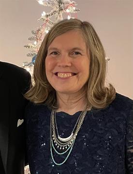 The woman beams with joy while surrounded by cheerful decorations, celebrating a special occasion.