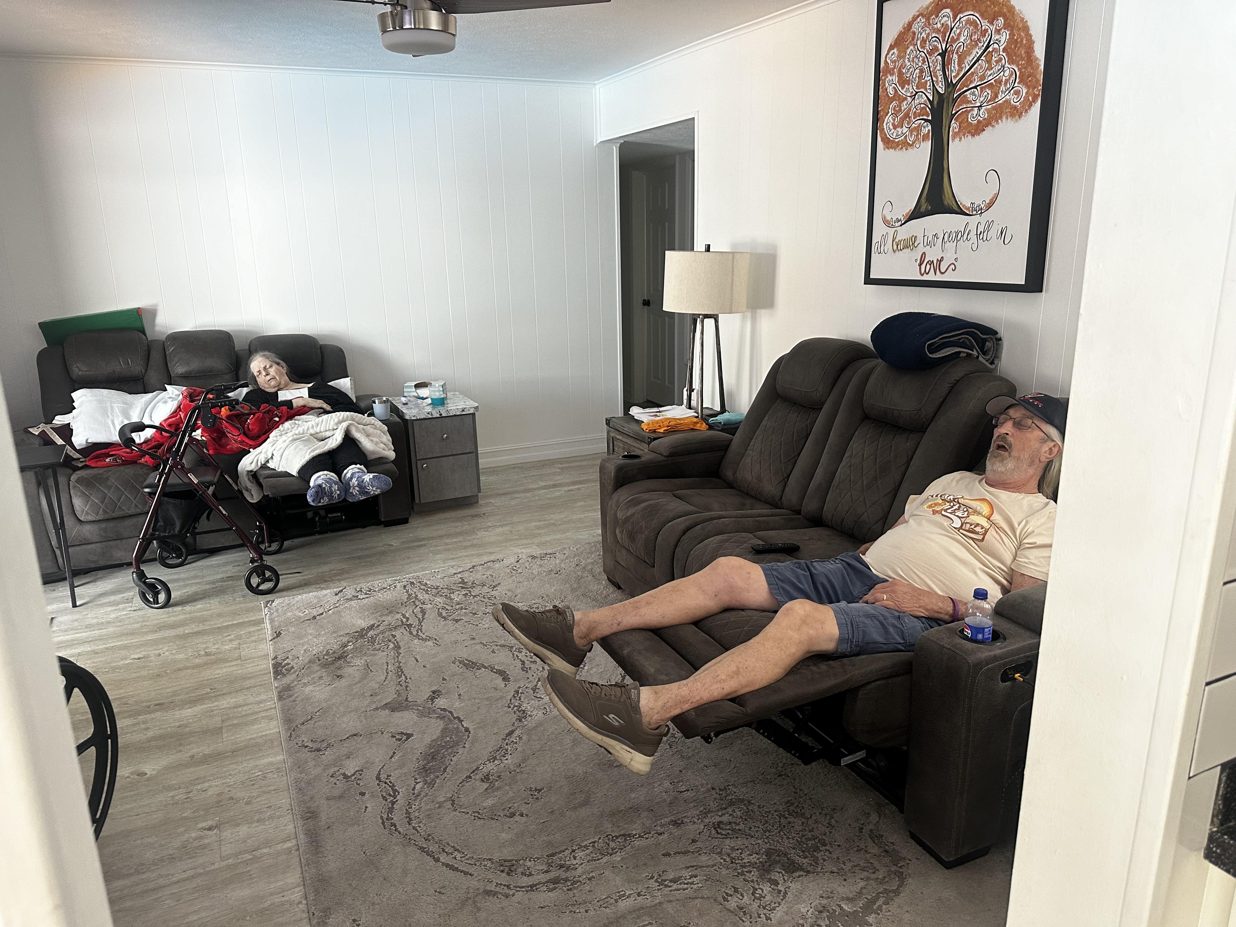 Two family members are resting in a welcoming living room, embracing a peaceful afternoon.