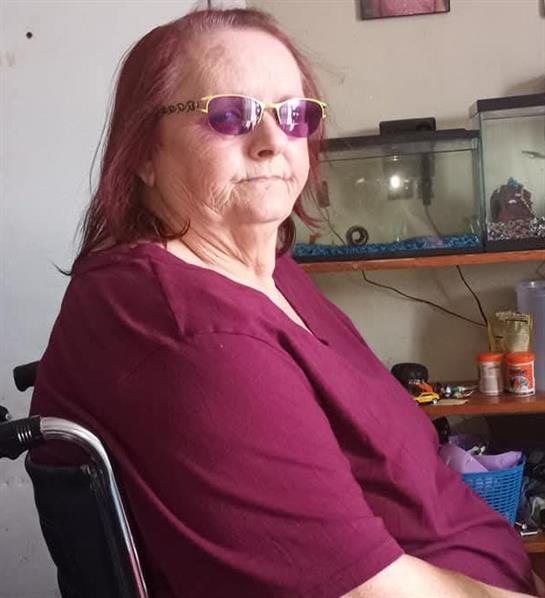 A woman in a wheelchair wearing sunglasses