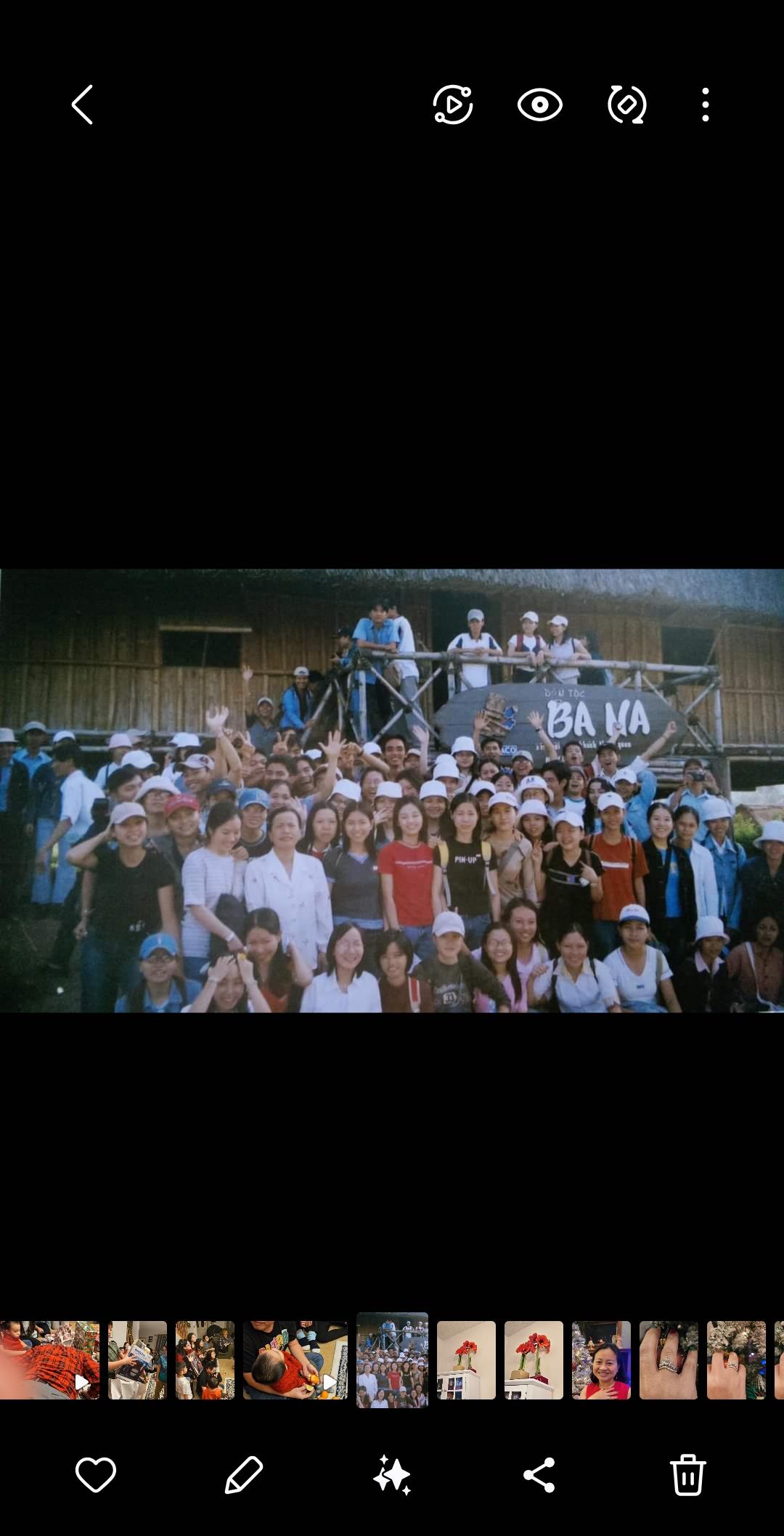 Many individuals pose together in a rural setting, celebrating a community gathering with joy.
