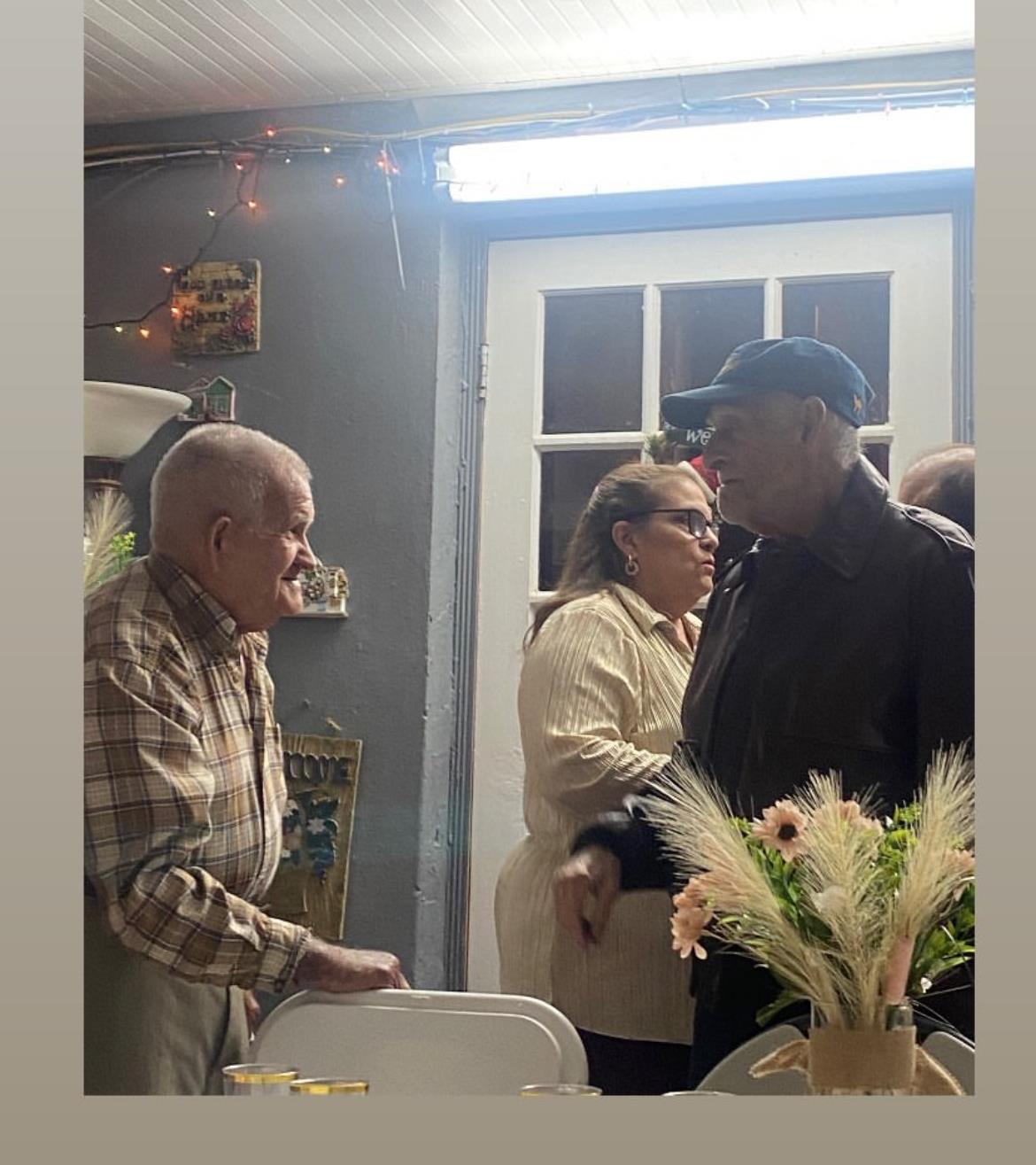 Friends enjoy warm conversations and laughter during a festive indoor celebration at night.