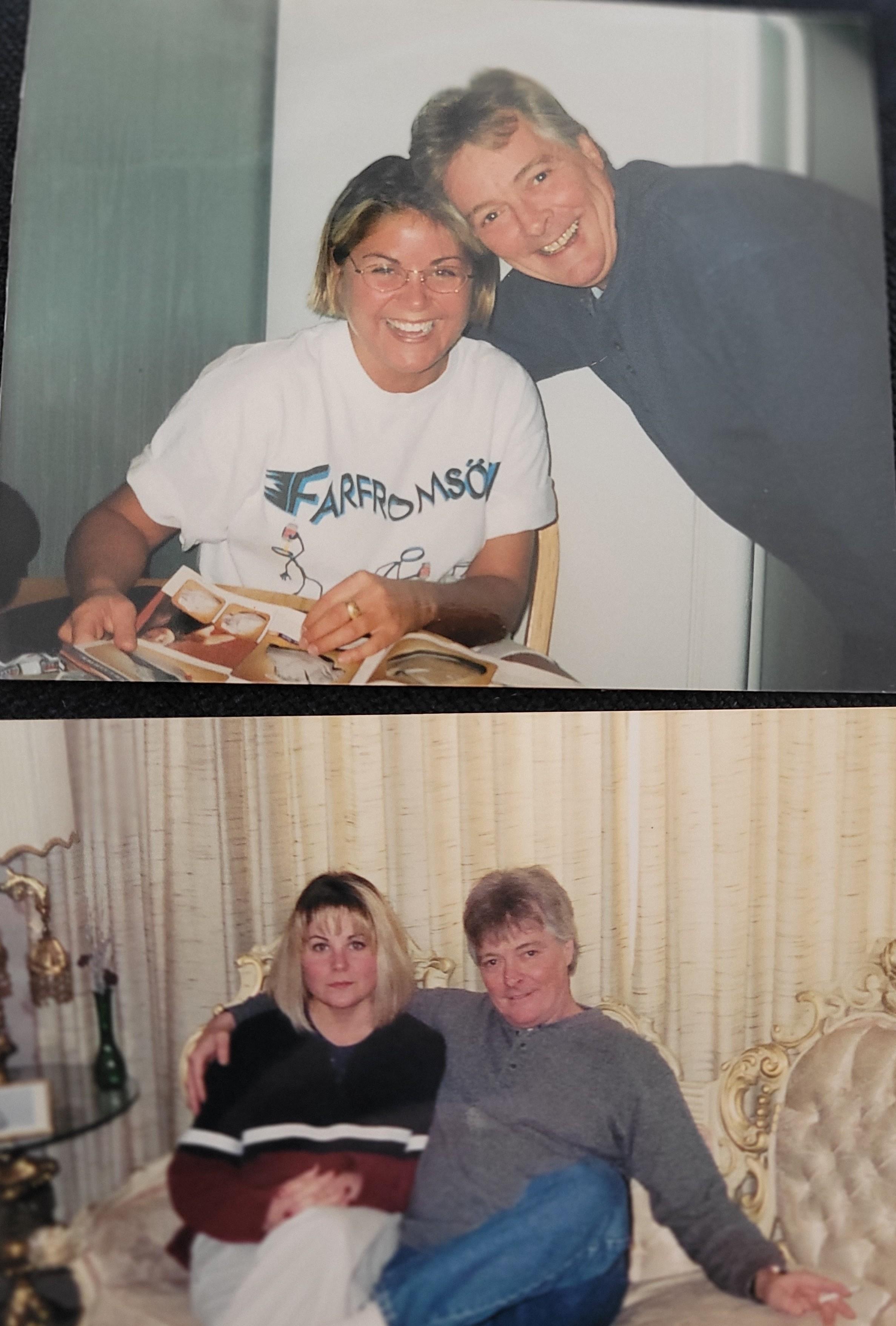 Two friends enjoy reminiscing over a collection of old photographs in a warm, inviting space.