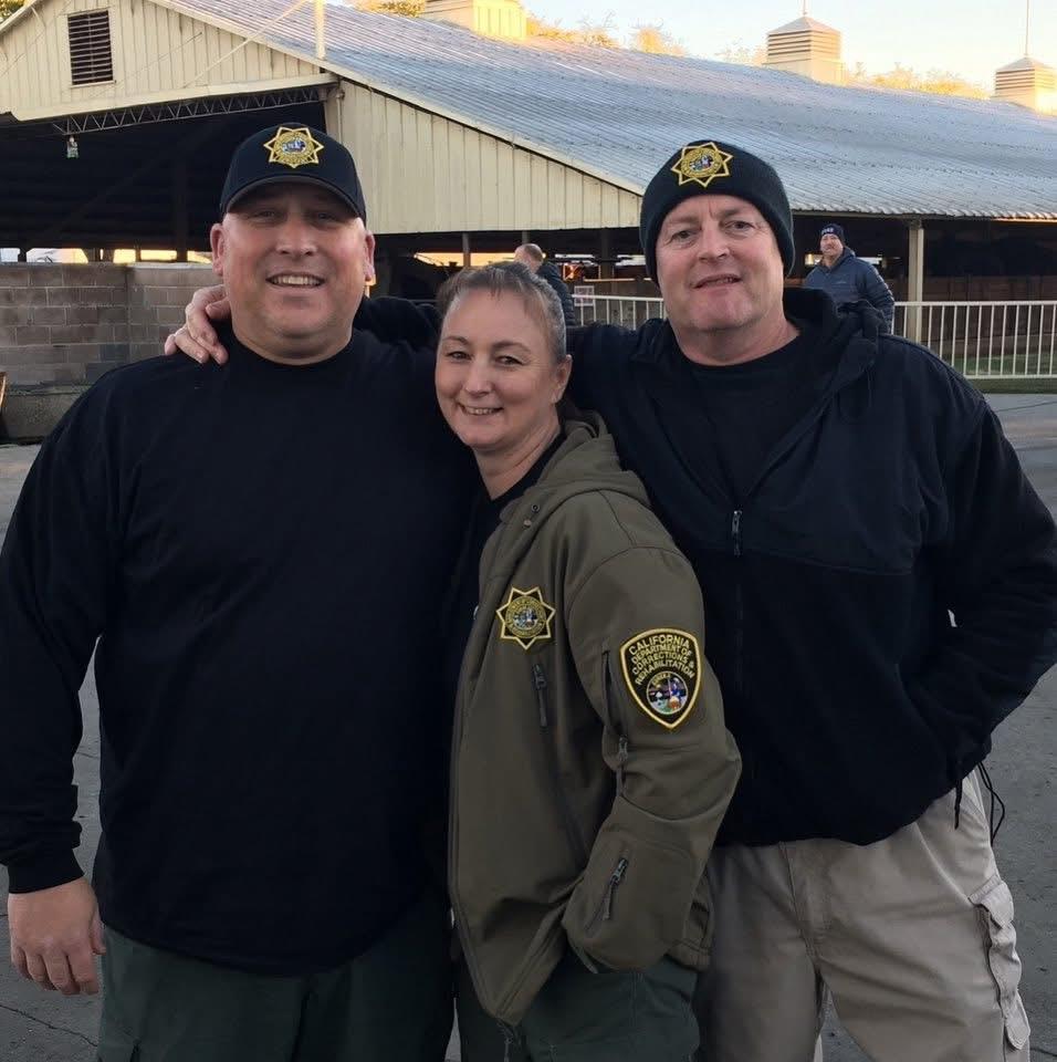Officers stand proudly together, smiling and wearing their uniforms at a local gathering.
