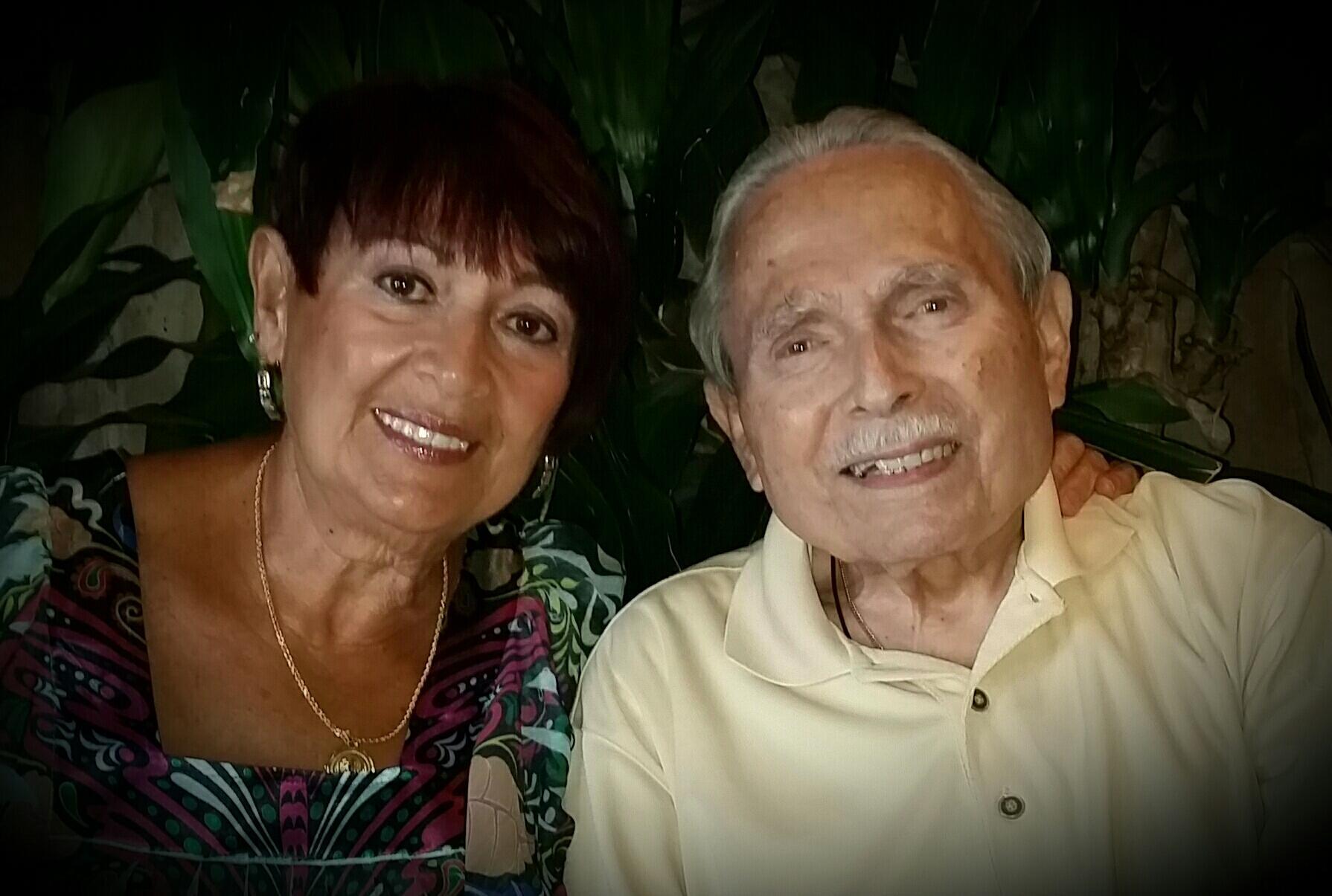 Happy couple smiles for a close-up photo, sharing a cherished moment in a cozy setting.