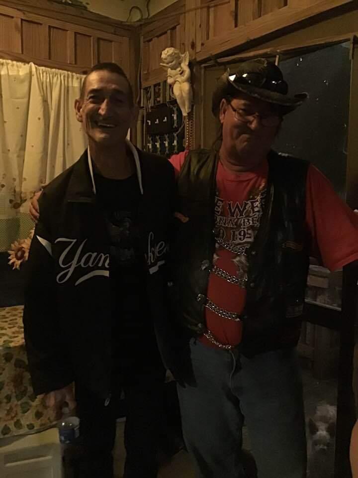 Two friends pose together in a warm, inviting space with a relaxed atmosphere.