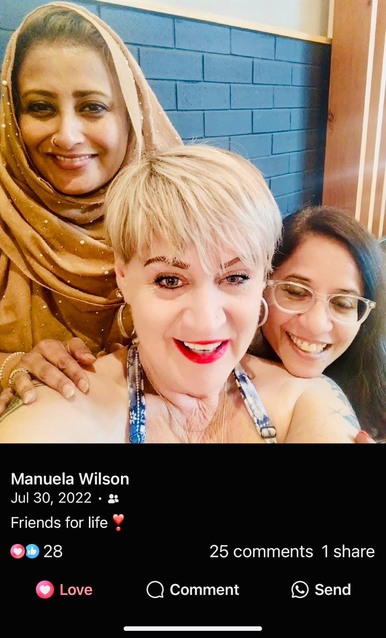 Friends enjoy a cheerful moment, posing closely with smiles at a gathering in a warm atmosphere.