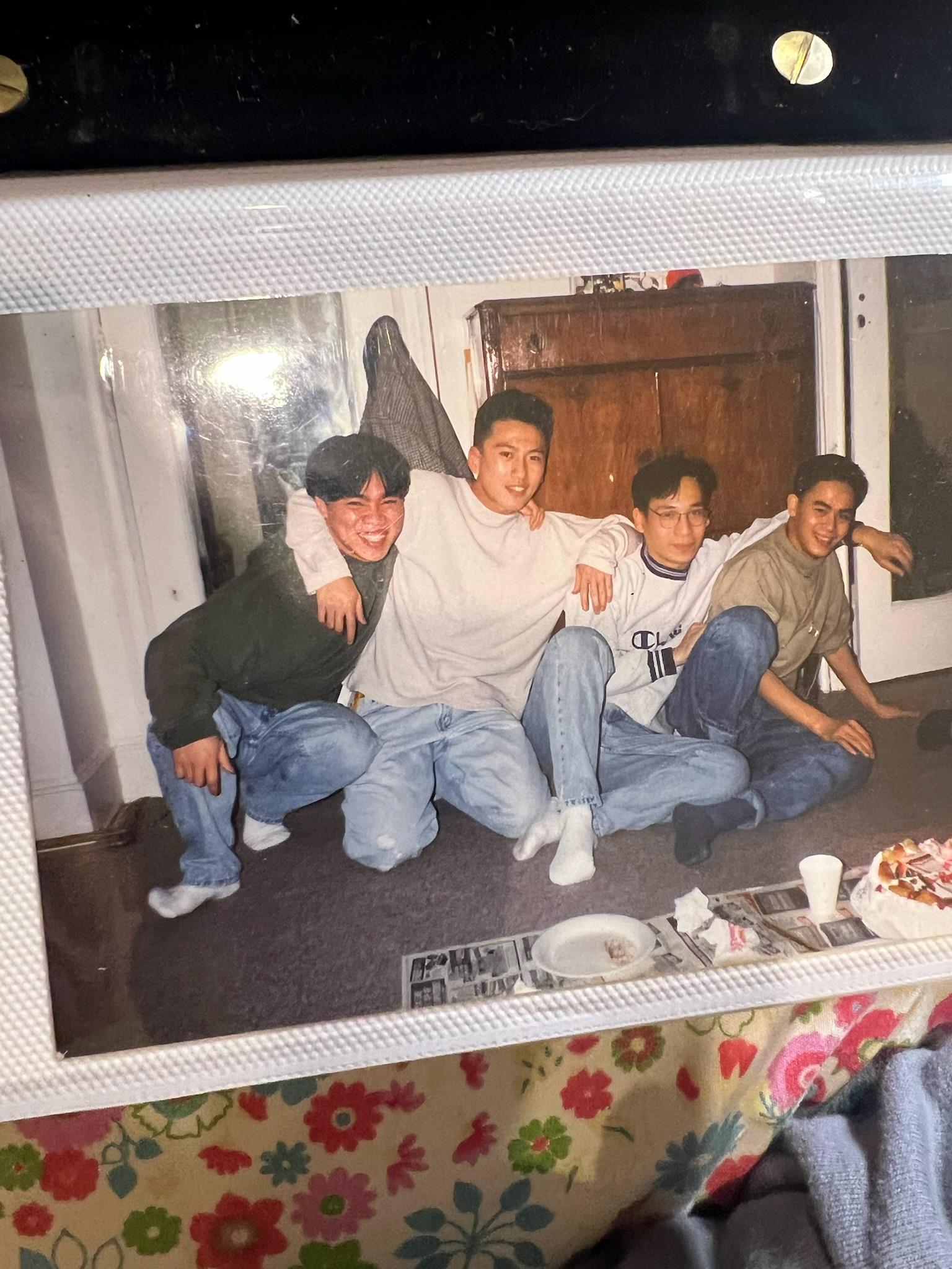 Four friends sitting on a living room floor, enjoying each other's company in a cozy setting.