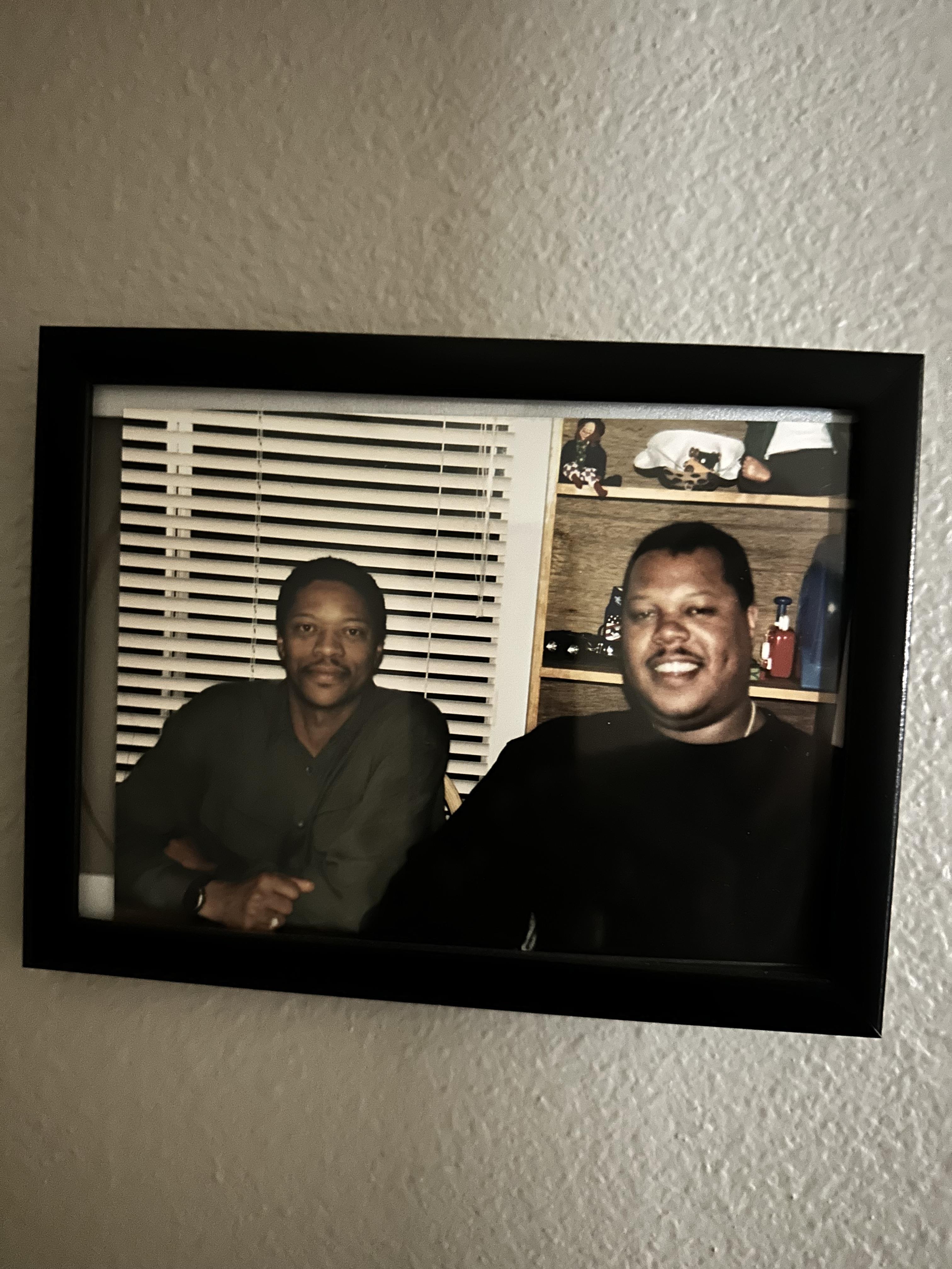 Two friends are enjoying their time together in a comfortable room with wooden shelves.