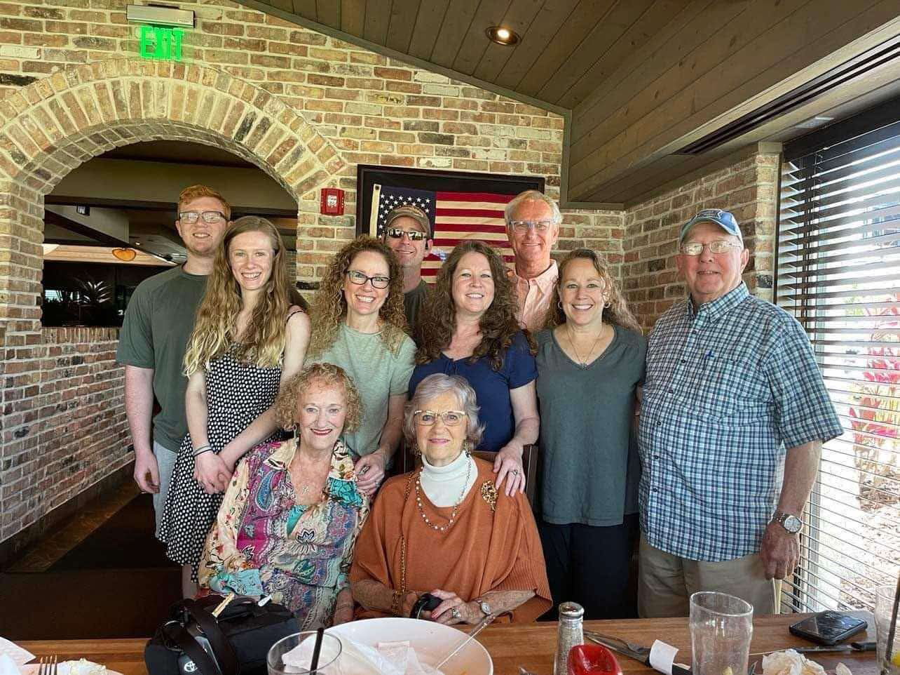 A group of family members enjoying a meal in a warm, inviting restaurant atmosphere.