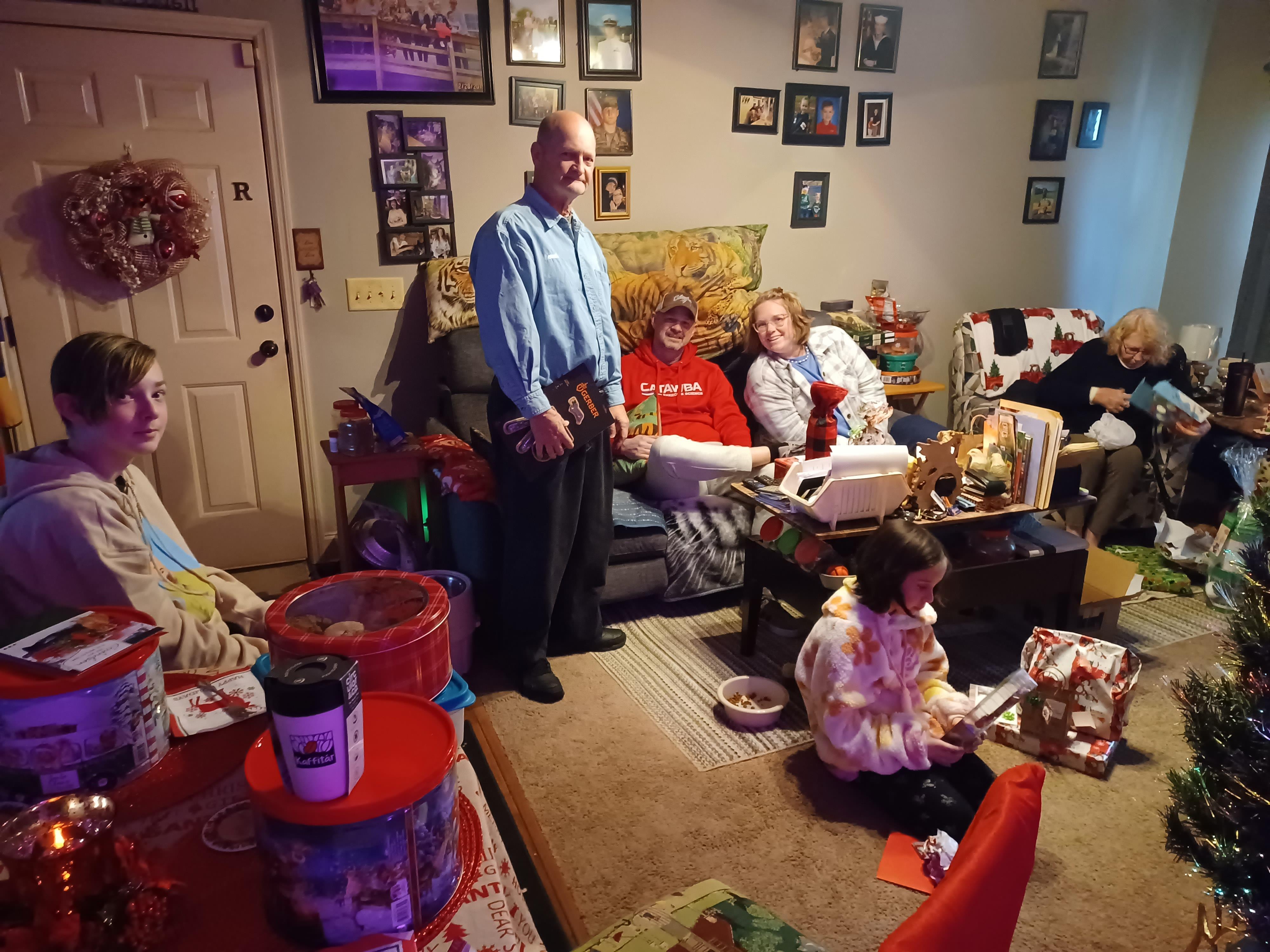 Family enjoys quality time together in a decorated living room during a holiday gathering.