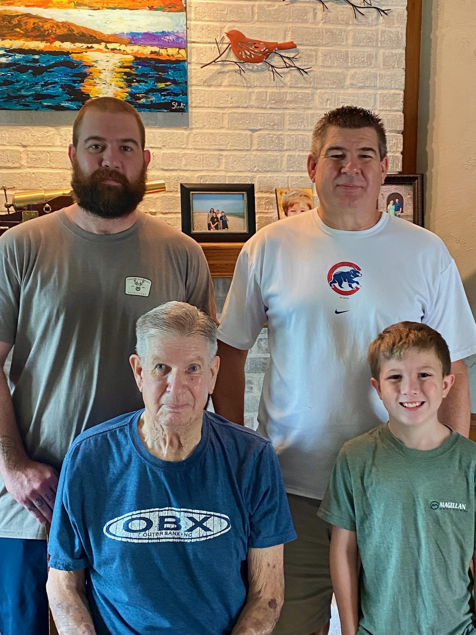 A family of four stands together, smiling in a bright living room filled with memories.