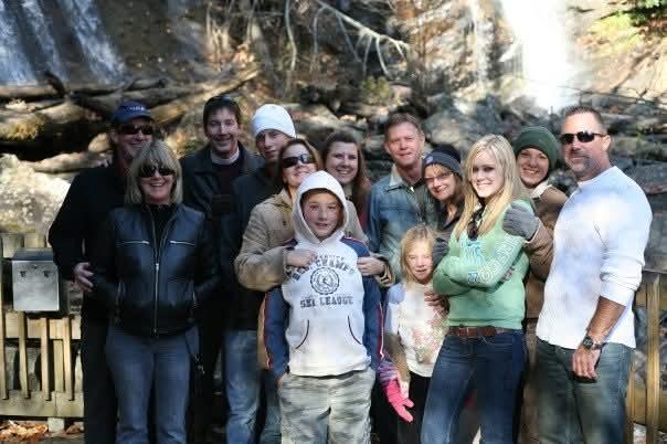 A group of friends and family enjoy a cheerful gathering in a beautiful natural setting.