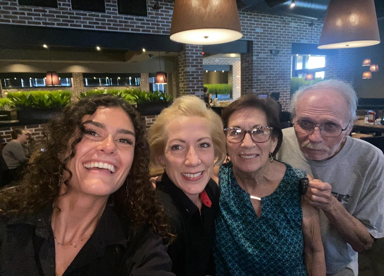 Group of friends smiling and posing together at a restaurant during a fun evening out.
