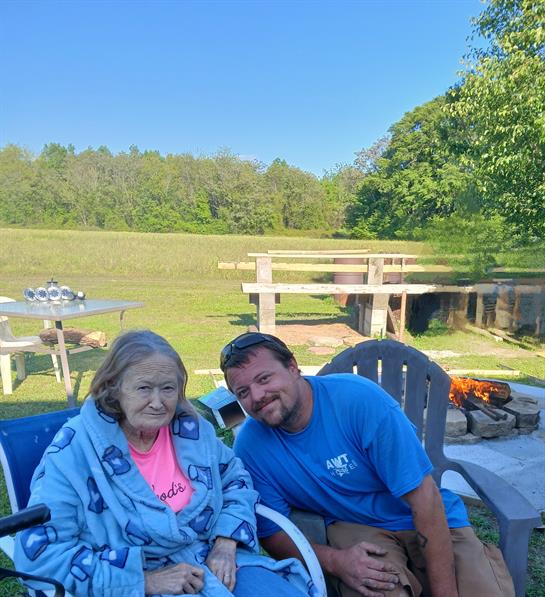 A man and woman sitting in chairs outside