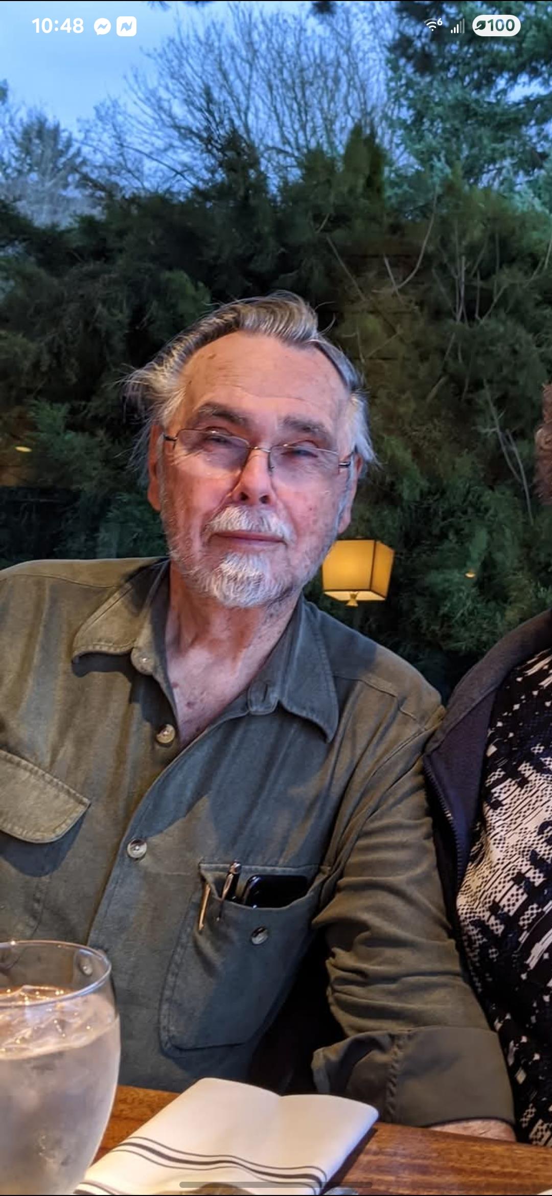 An elderly couple sits comfortably in a cozy indoor setting, engaging in conversation together.