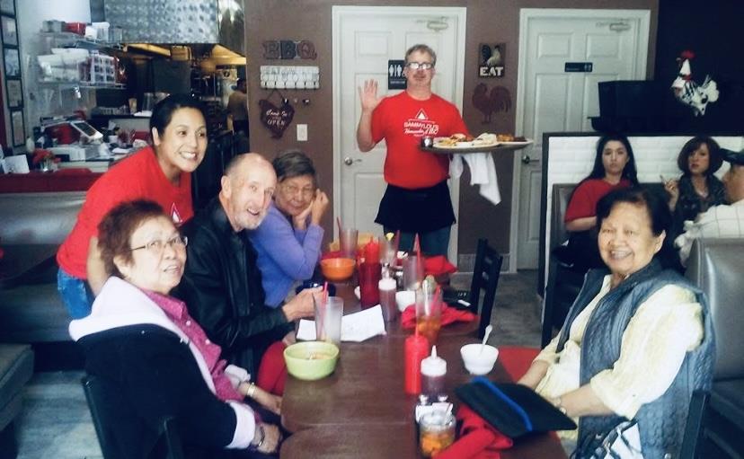 Group of friends laughing and sharing a meal at a restaurant, creating fond memories.