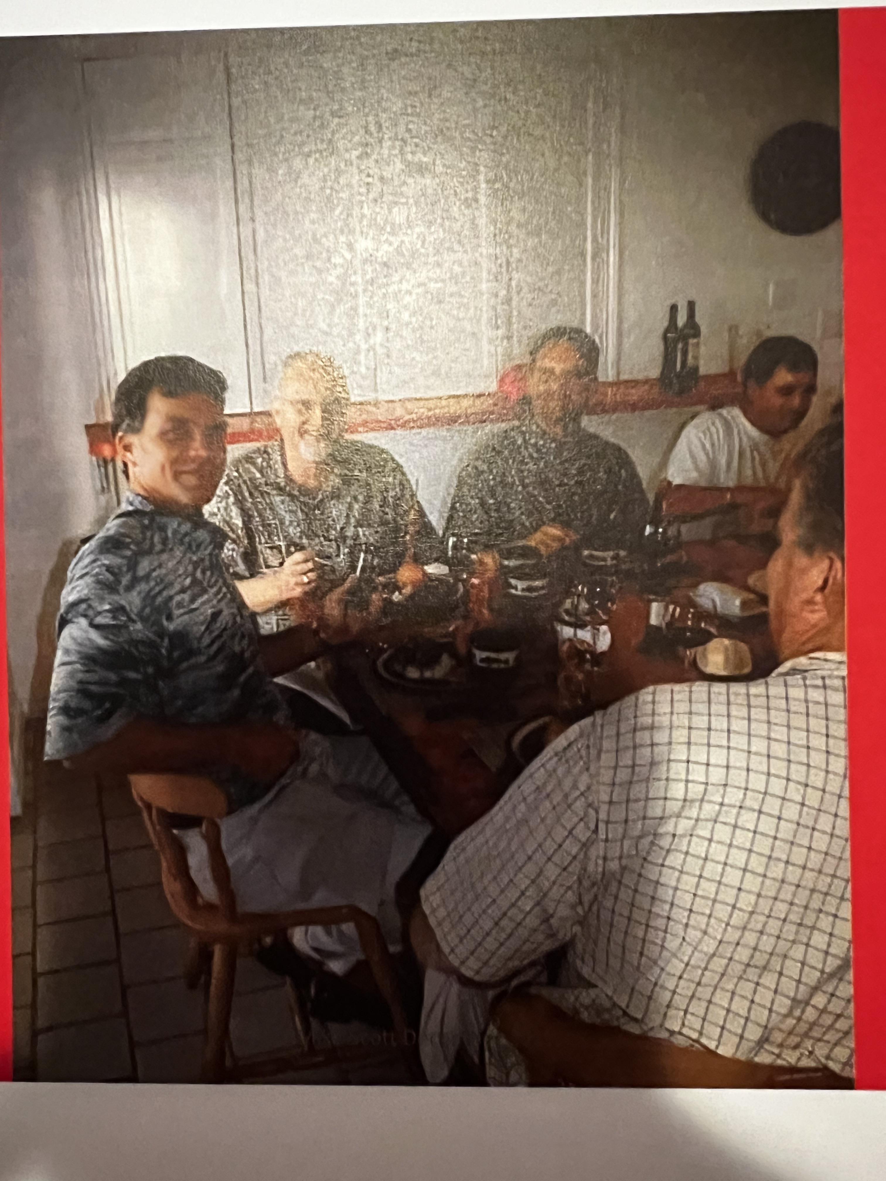 Six friends gather at a table, savoring food and drinks while chatting together.