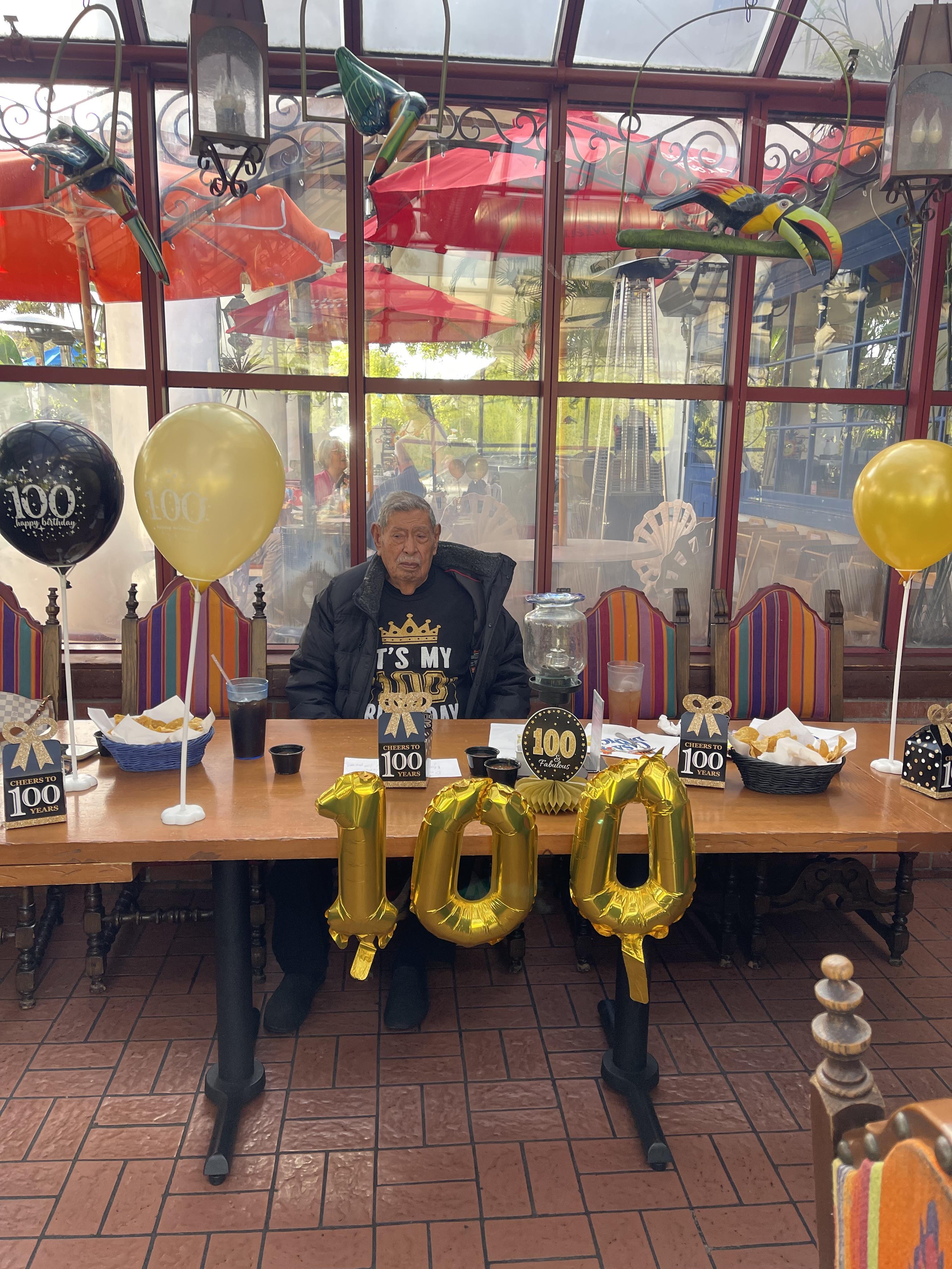 Family and friends gather to celebrate a milestone birthday with decorations and food present.