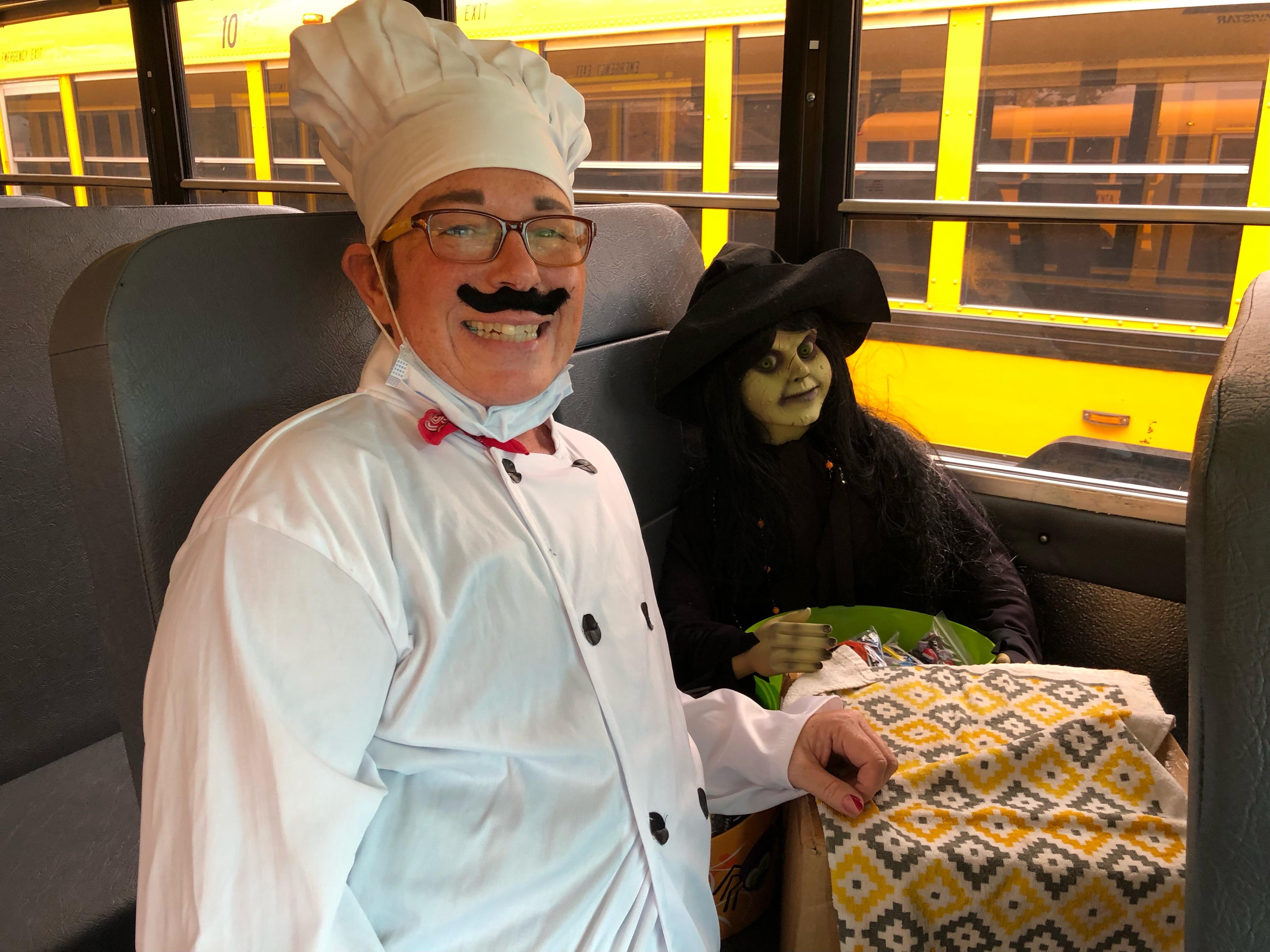 Two people in costumes share a moment on a bus, enjoying festive celebrations during Halloween.