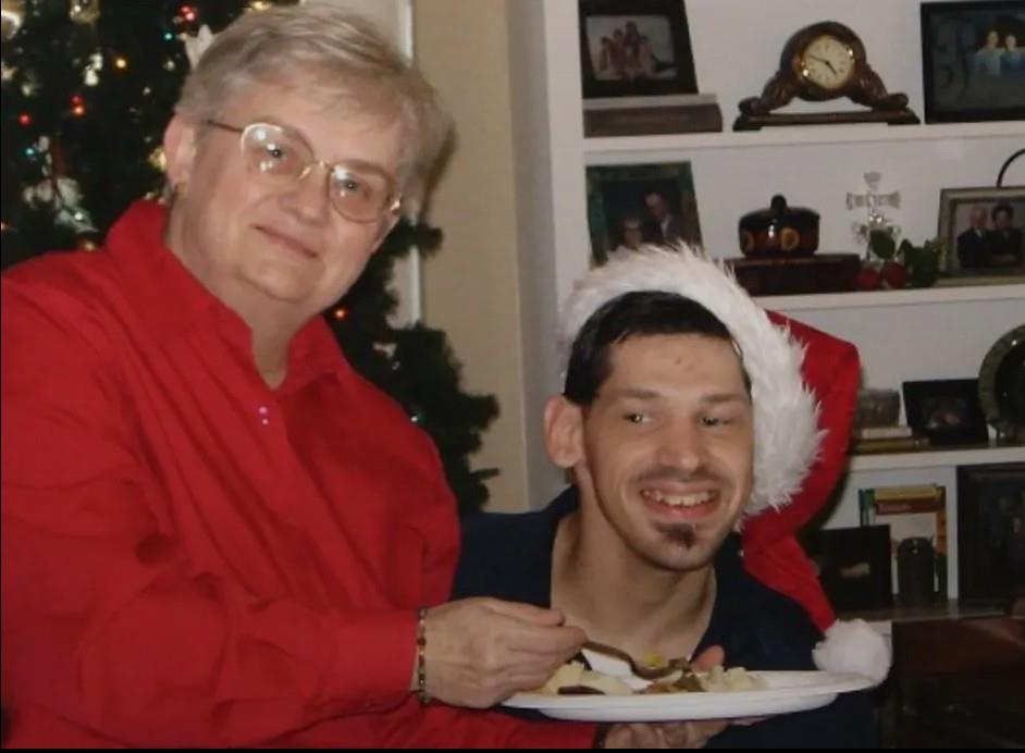Two individuals share a joyful moment during a festive celebration with holiday decorations around.