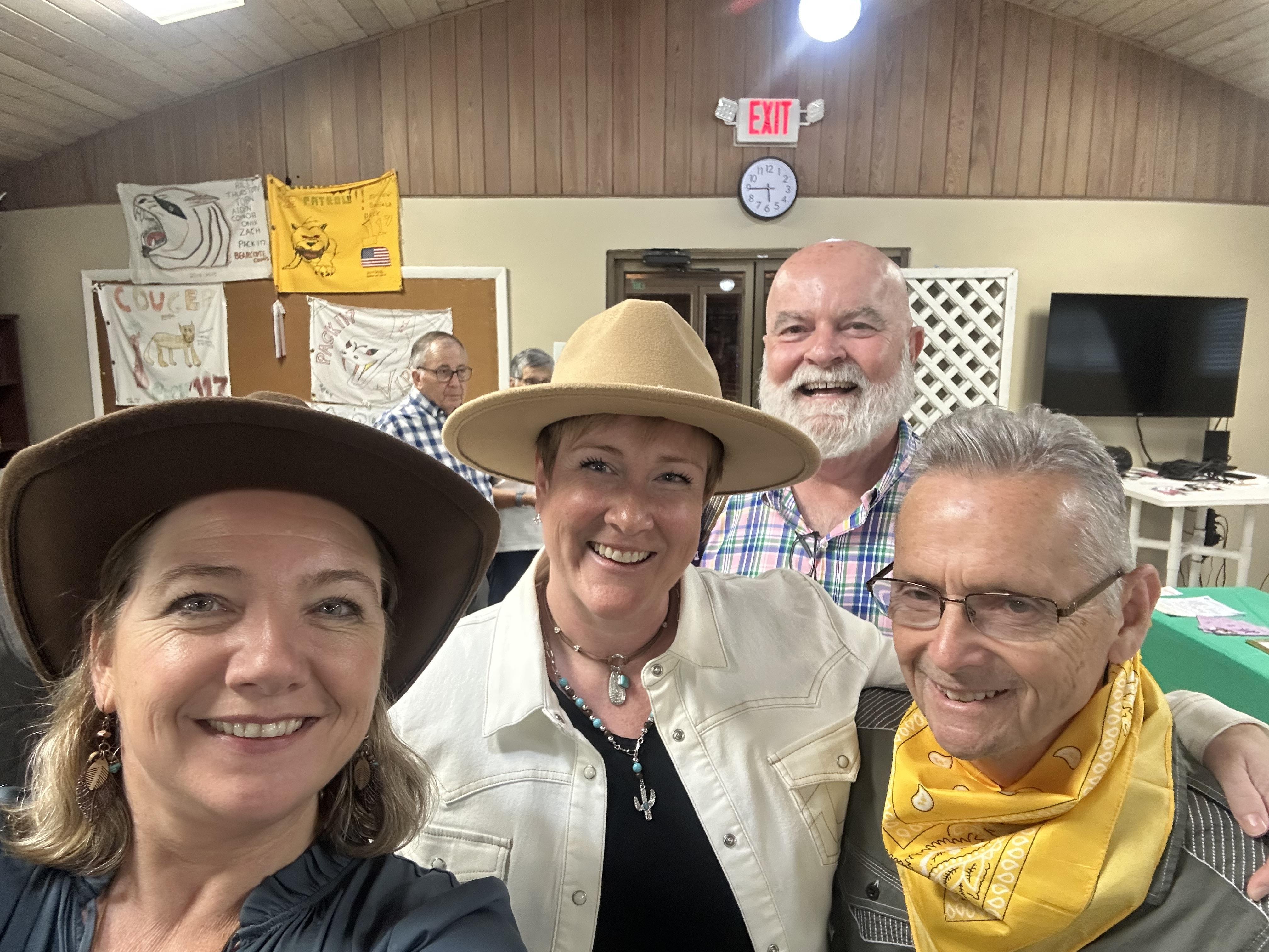A group of four friends enjoys a lively moment in a community center, sharing smiles and laughter.