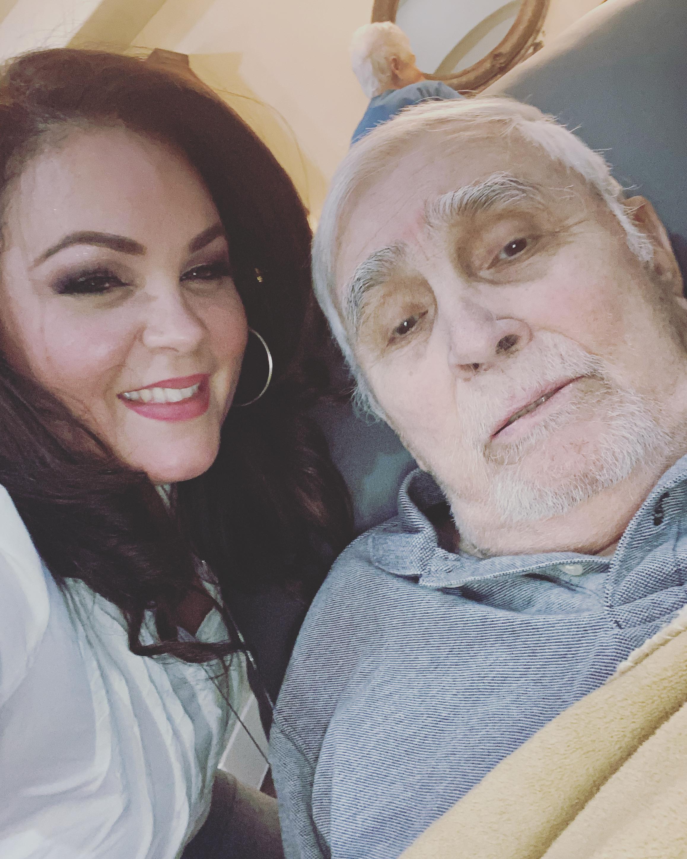 A woman smiles affectionately next to an elderly man, creating a heartwarming atmosphere.