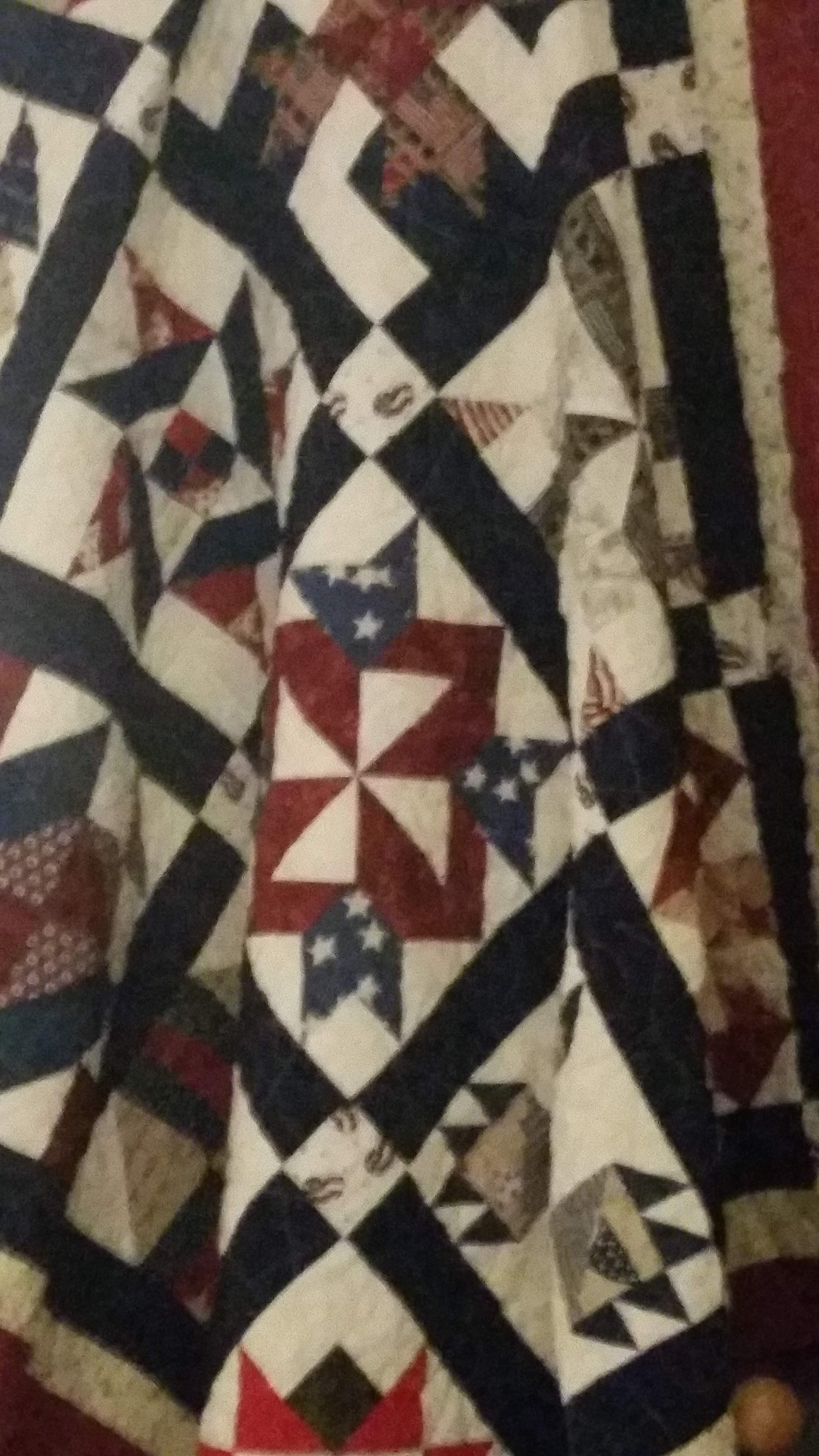 Quilt showcases intricate patterns of stars and geometric shapes at a local craft exhibition.