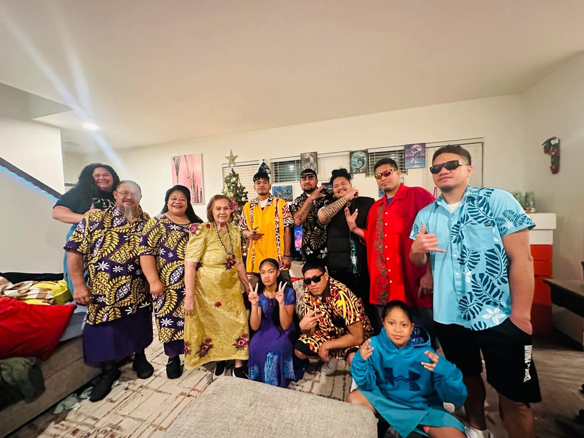 A vibrant family gathering features people in traditional attire celebrating a special occasion.