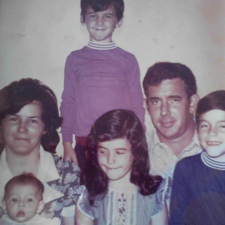 A loving family smiles together in their living room, showcasing happiness and togetherness.