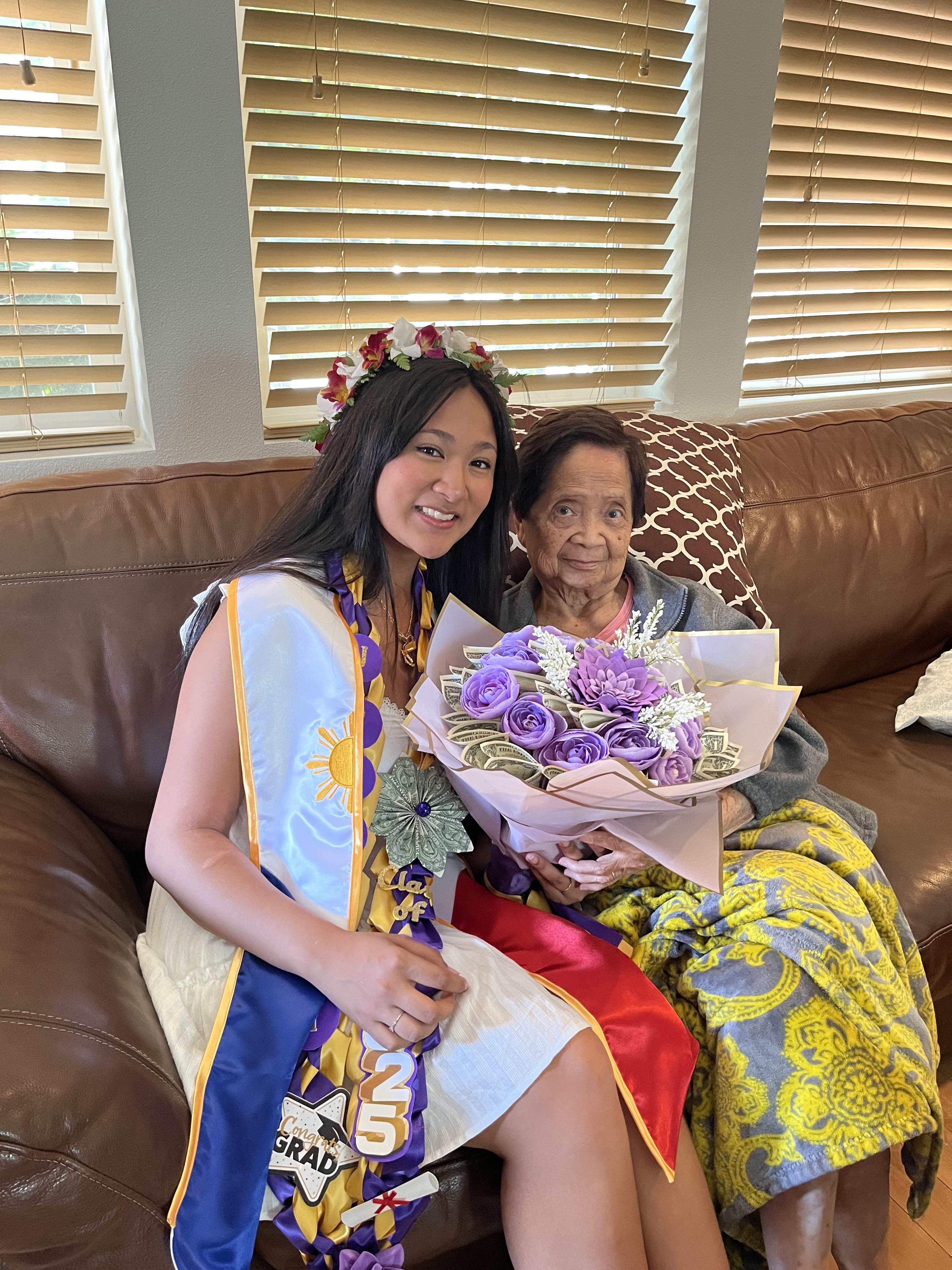A young woman presents a bouquet of flowers to her grandmother in a joyful family gathering.