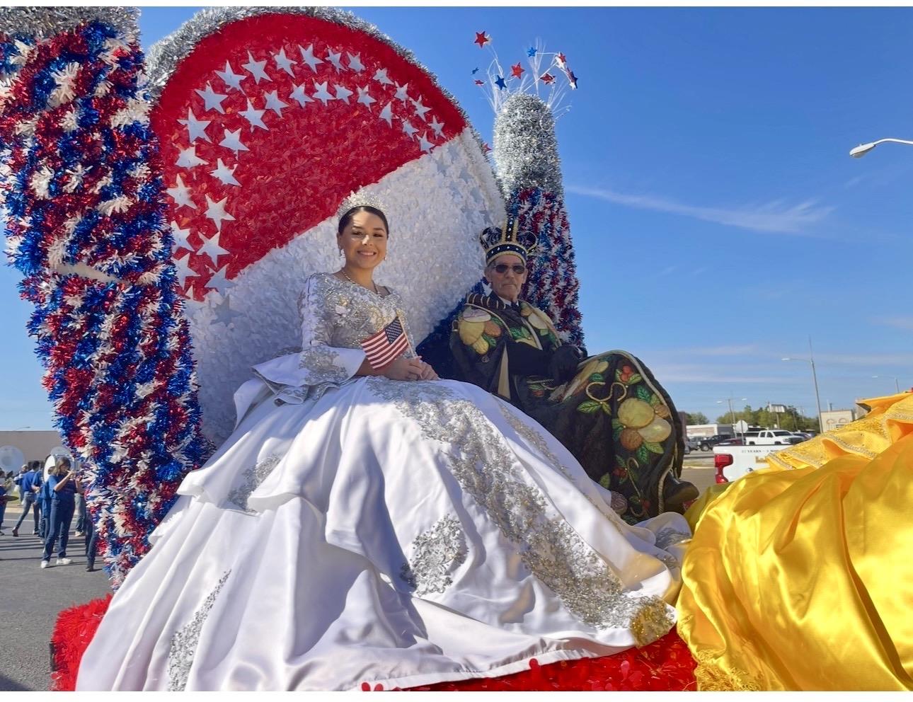 A man and woman in a dress sitting on a float