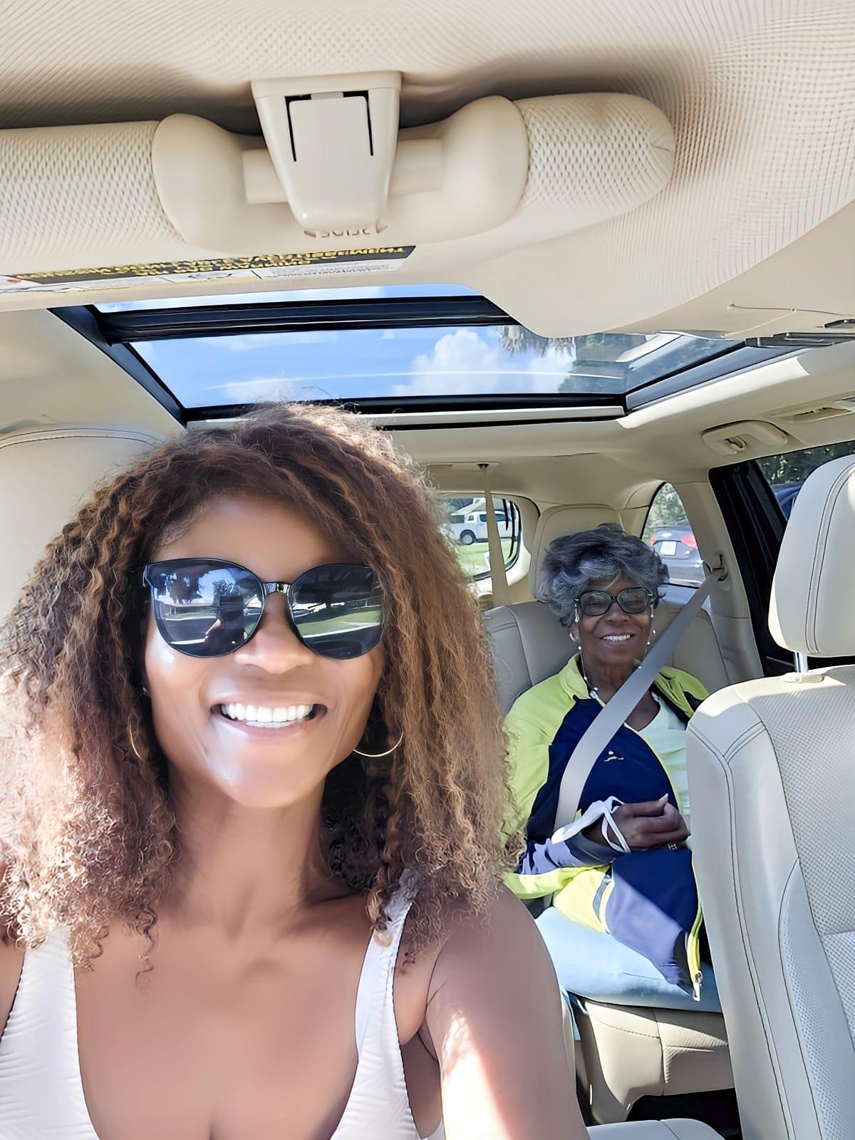 Two friends smile and enjoy a sunny day during a fun car ride.