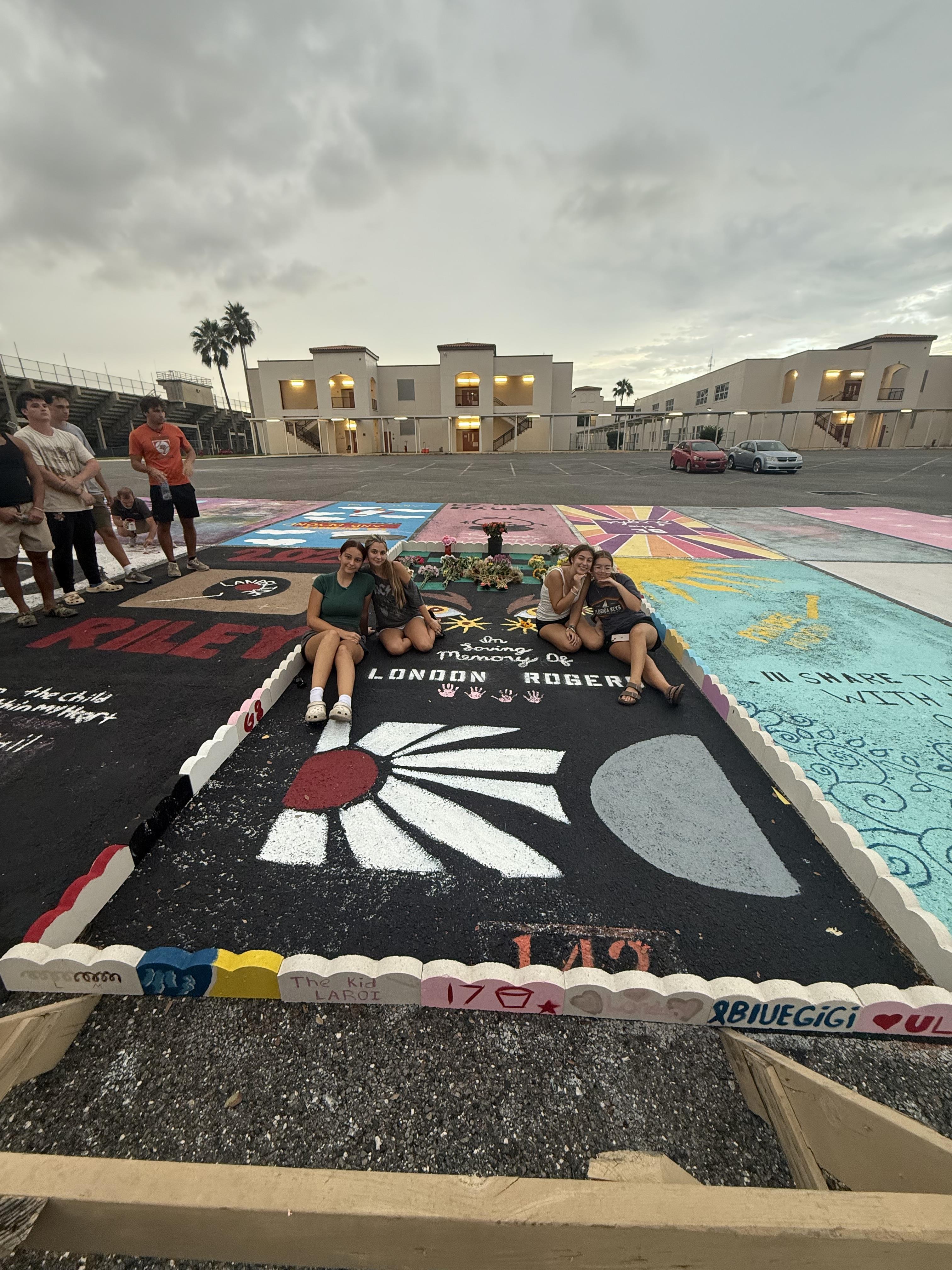Friends gather together to create colorful mural artworks during the evening in an open area.