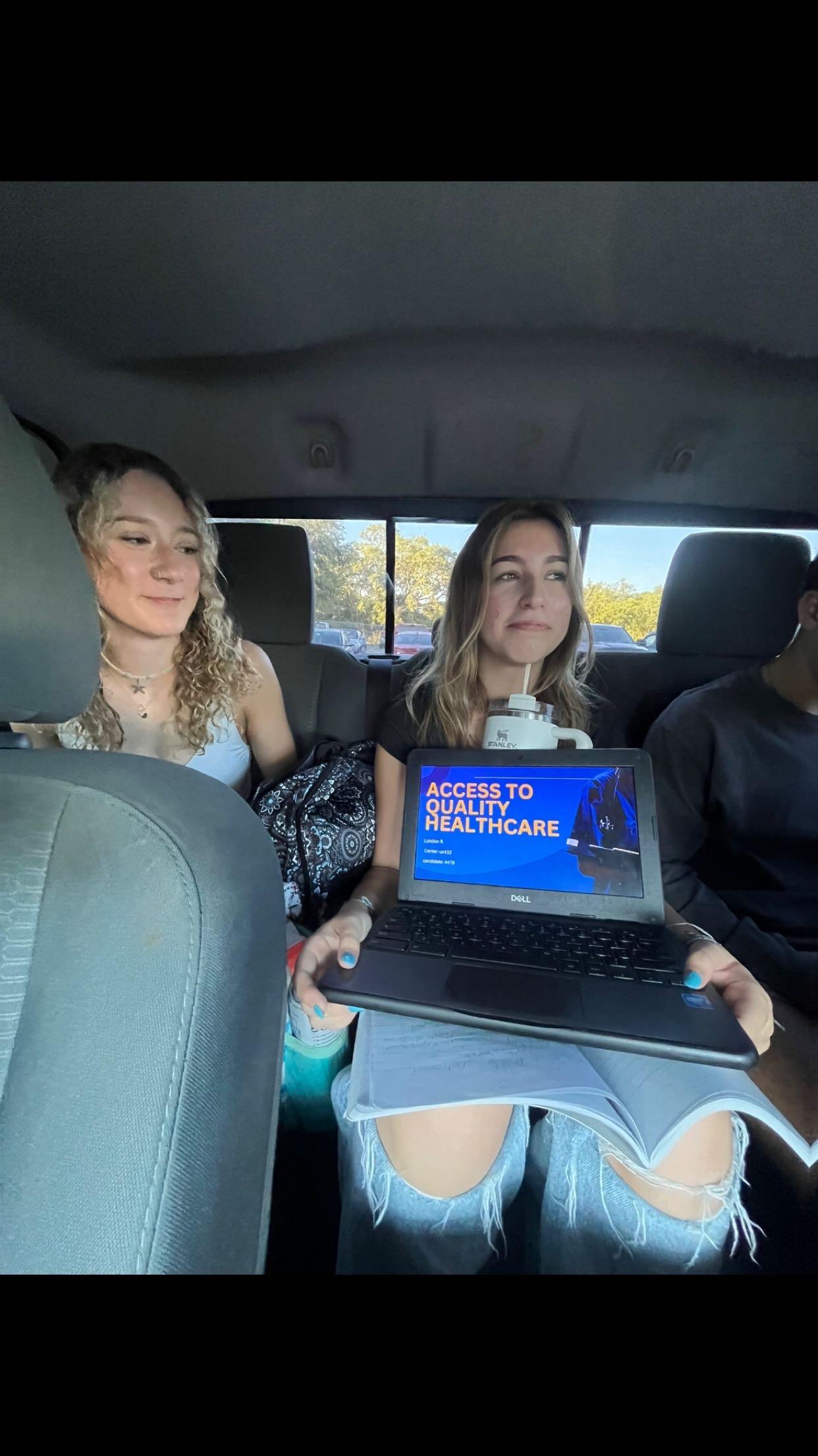 Three people inside a vehicle engage in a discussion about healthcare access.