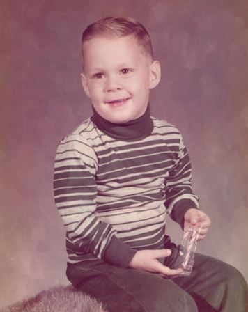 A young boy holding a clear plastic bottle
